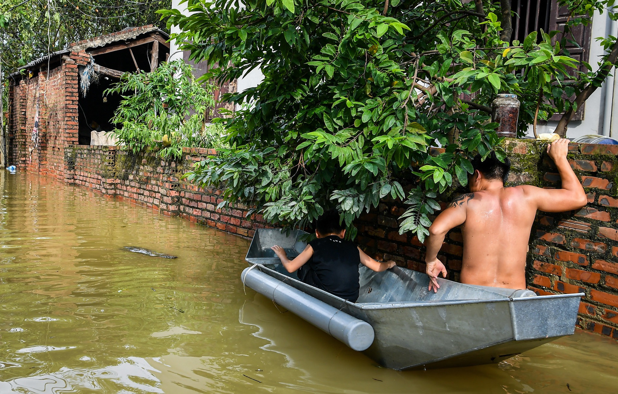 Dù đã rút bớt, nhưng nước lũ vẫn gần ngập bức tường cao tới hơn 2m. Dù đã rút bớt, nhưng nước lũ vẫn gần ngập bức tường cao tới hơn 2m.