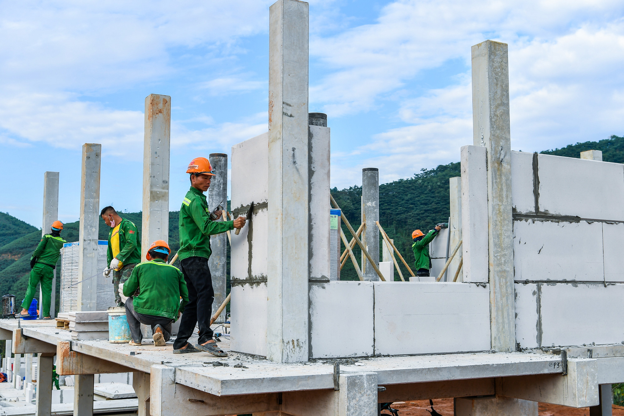 Những người công nhân mang màu áo lính miệt mài trên công trường ngày cuối tháng 10.