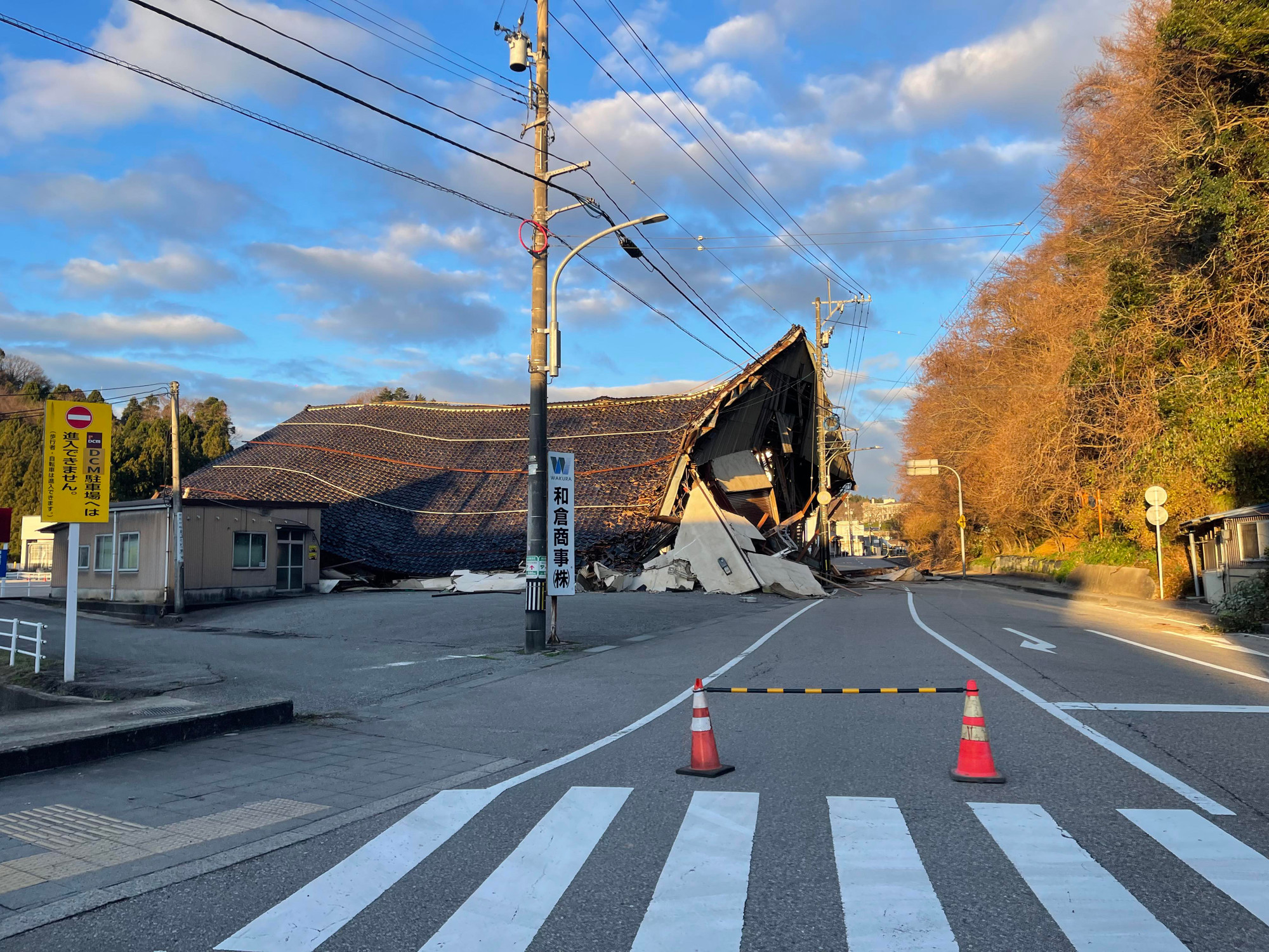 Con đường tiếp cận một điểm cứu trợ của đoàn do anh Được tổ chức. Phía xa, đường đã bị nứt gãy và có biển cấm vào.