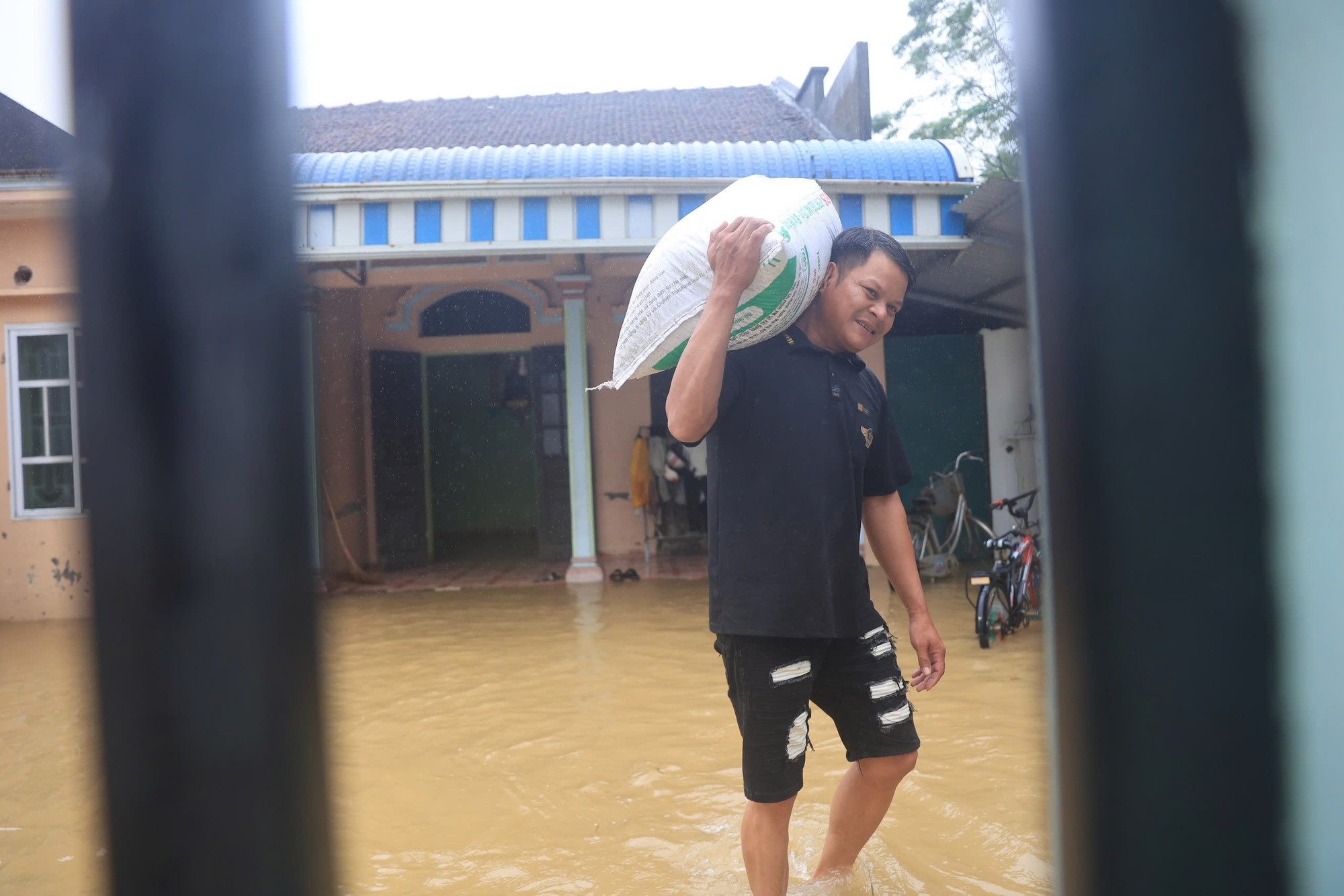 Một người dân tranh thủ di chuyển đồ đạc có giá trị ra khỏi căn nhà. Vào thời điểm sáng 11/9, nước đã mấp mé ngôi nhà của gia đình ông.