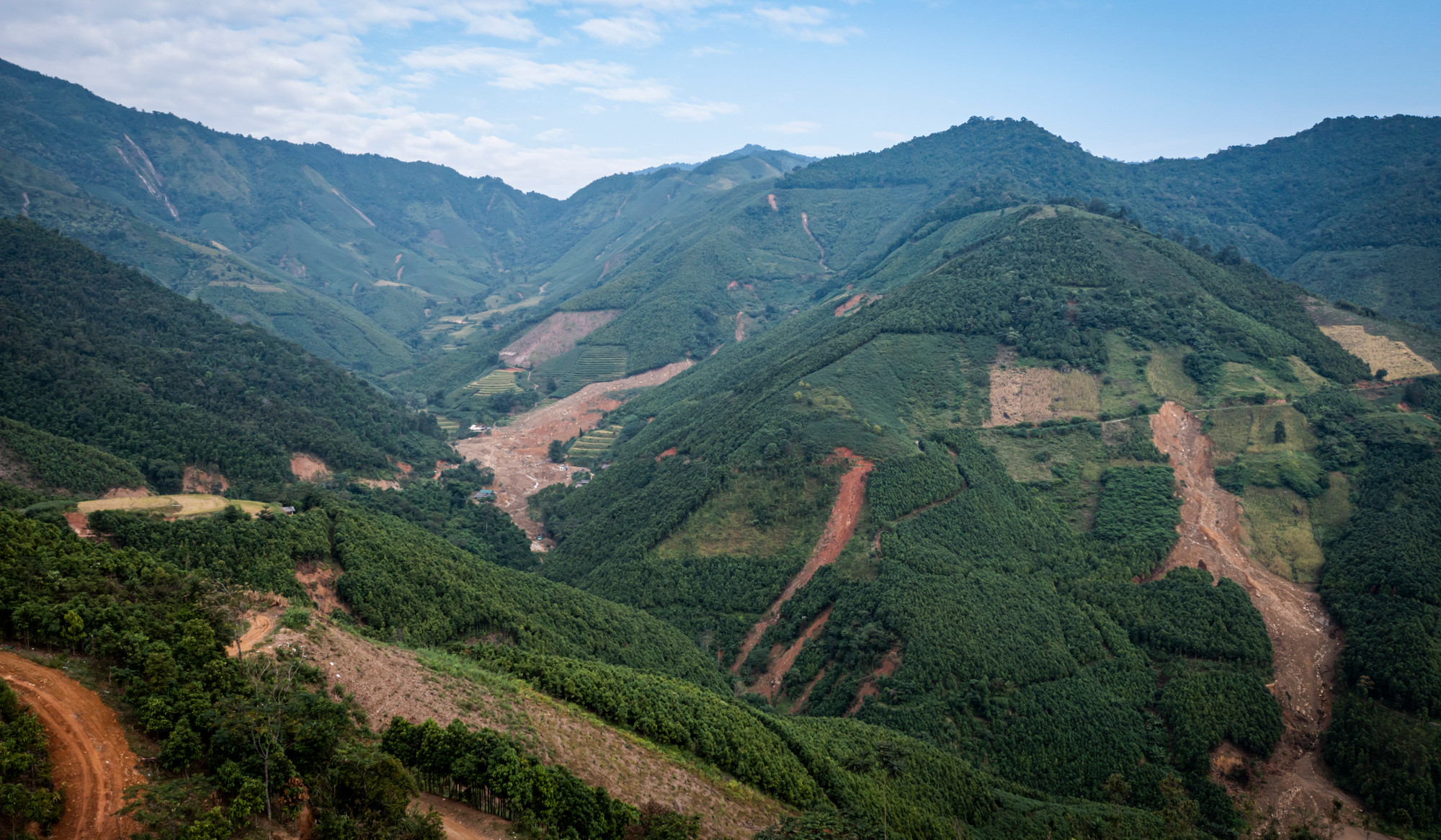 Phía xa xa, những ngọn đồi vẫn loang lổ vệt sạt màu nâu đỏ; tựa như tấm áo màu xanh ai xé toạc ra giữa trời...