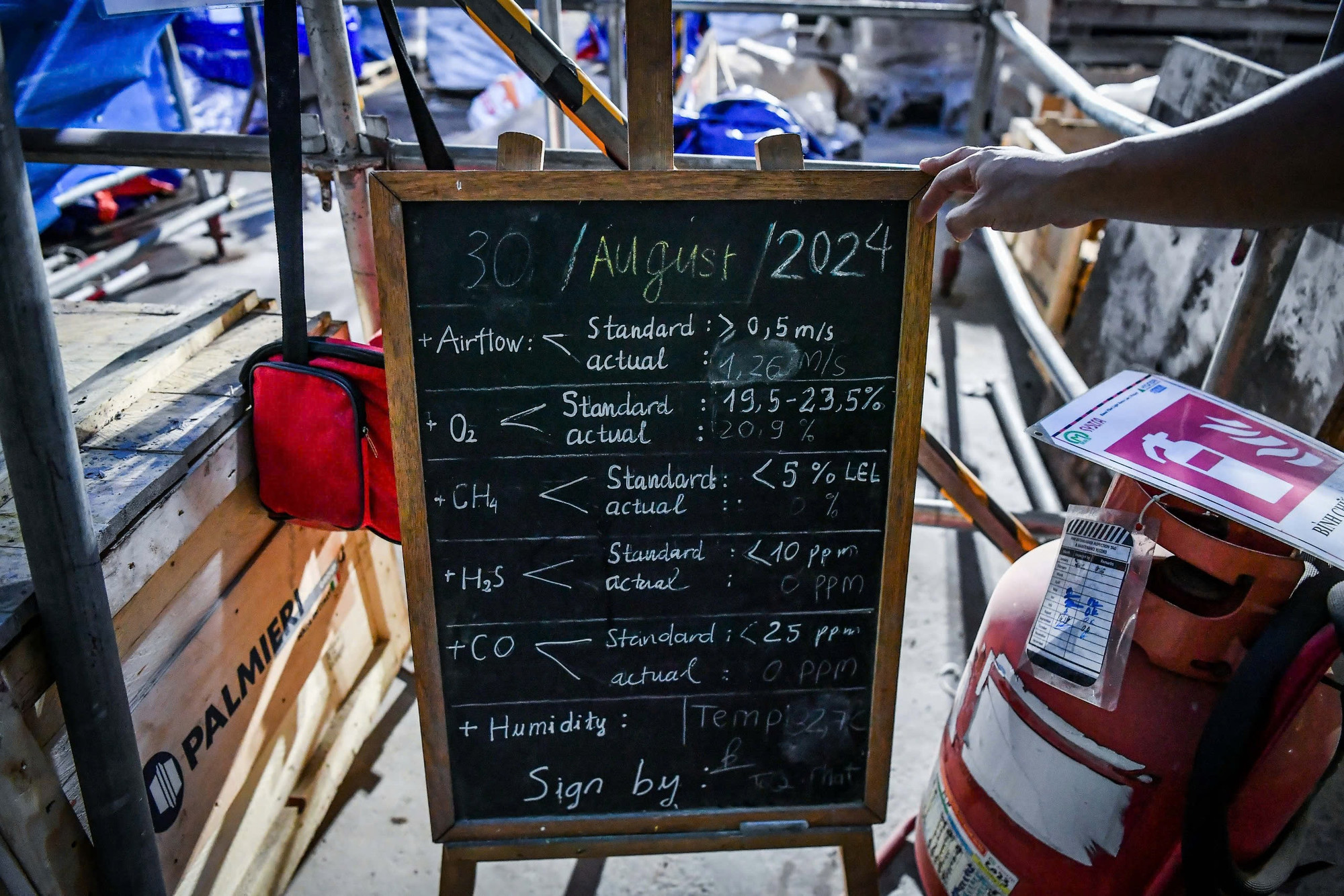 Do phải thi công dưới độ sâu hàng chục mét so với lòng đất, việc bảo đảm an toàn khi làm việc luôn được đặt lên hàng đầu. Ngay khi bước xuống tầng ngầm số 2 của công trường, tất cả sẽ bắt gặp một tấm bảng ghi lại thông số chất lượng không khí ngày hôm đó.