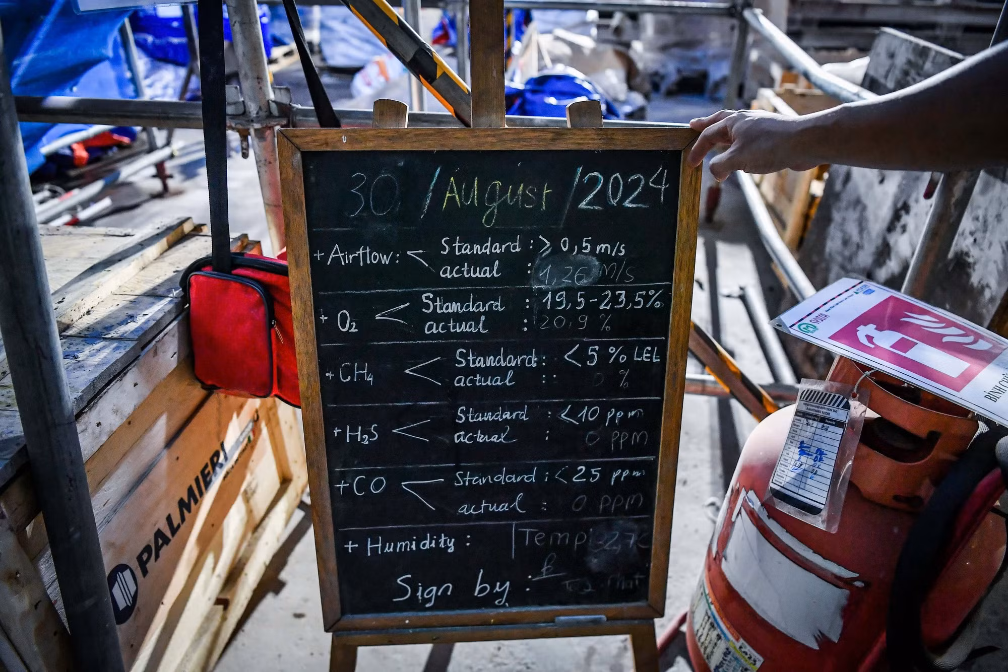 Do phải thi công dưới độ sâu hàng chục mét so với lòng đất, việc bảo đảm an toàn khi làm việc luôn được đặt lên hàng đầu. Ngay khi bước xuống tầng ngầm số 2 của công trường, tất cả sẽ bắt gặp một tấm bảng ghi lại thông số chất lượng không khí ngày hôm đó.