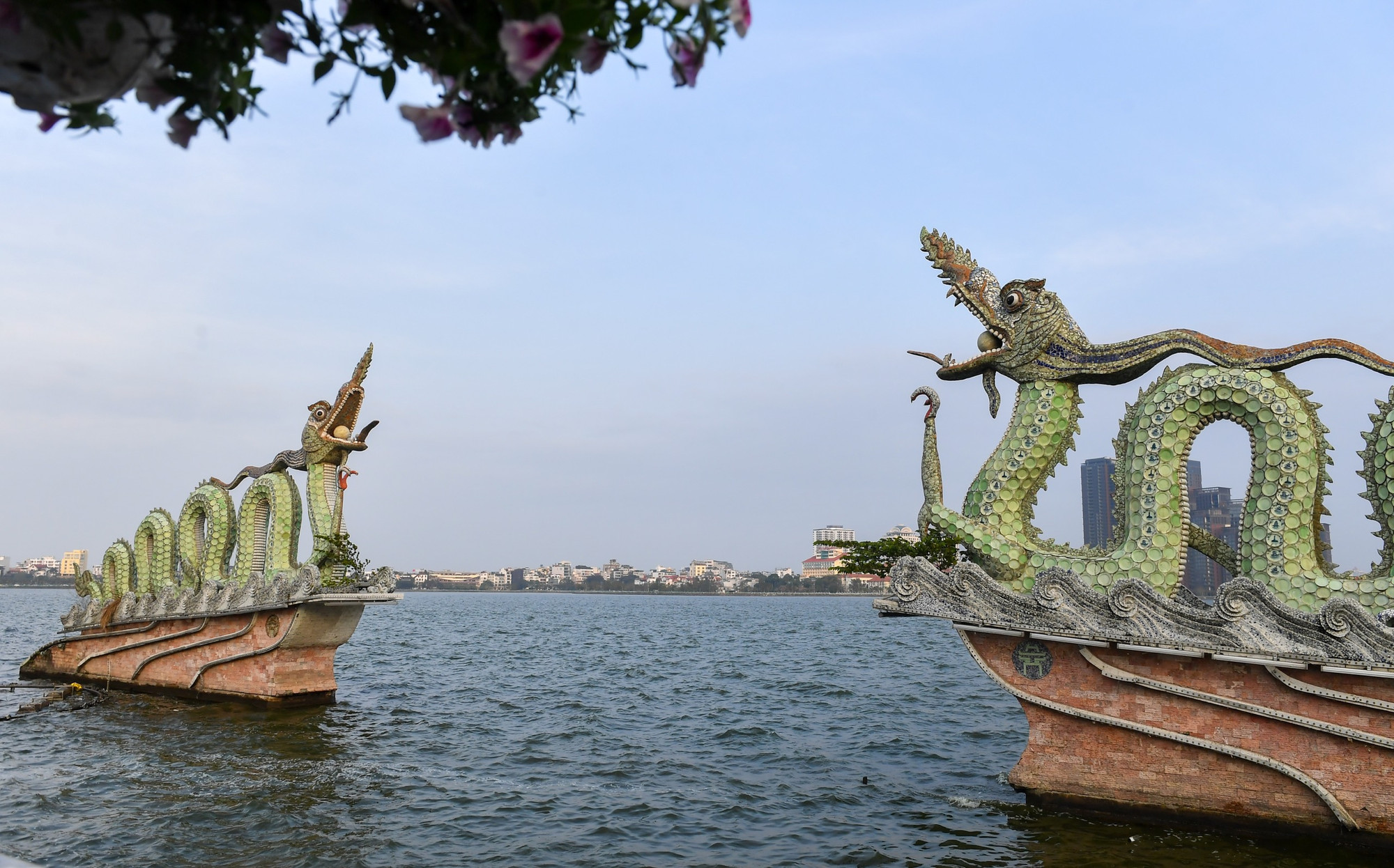 Khi chuyển về đây, 2 con rồng đã được thiết kế thêm cột đèn chiếu sáng, đài phun nước để tăng thêm vẻ đẹp sống động. Việc lắp đặt được tiến hành tỉ mỉ, một rồng chầu hướng bắc, một rồng chầu hướng nam. Phía trước là không gian mặt nước rộng lớn, phía sau là Vườn hoa Lạc Long Quân tạo một điểm nhấn đẹp.