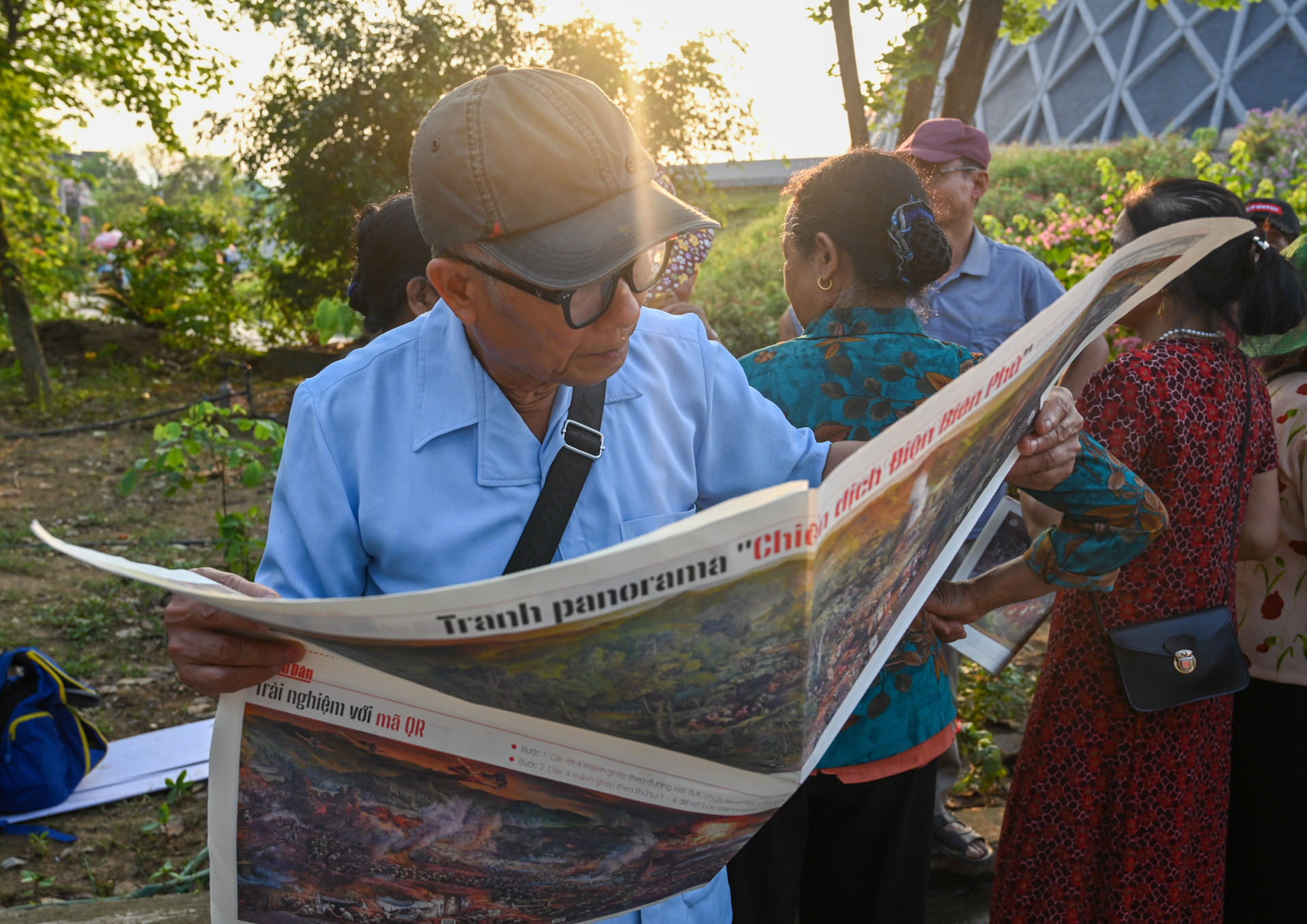 Một độc giả chăm chú xem phụ bản đặc biệt của Báo Nhân Dân.