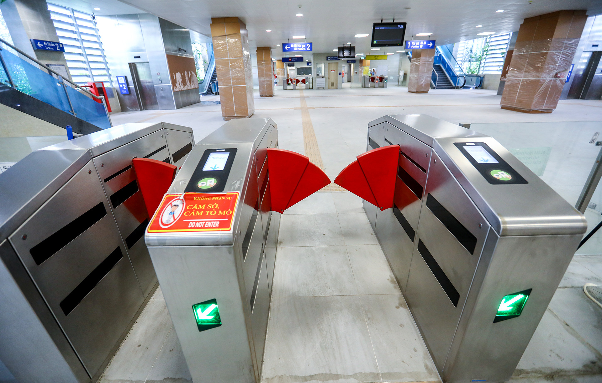 Tiếp đến, hành khách sẽ đi qua cửa kiểm soát được thực hiện bằng hệ thống kiểm soát tự động. Nếu thẻ/vé hợp lệ, cửa sẽ tự động mở cửa để hành khách đi qua. Hành khách đi theo biển chỉ dẫn đúng hướng tàu theo lịch trình và di chuyển lên khu vực đợi tàu. Chú ý giữ lại thẻ/vé để lặp lại các bước soát thẻ/vé một lần nữa tại ga đến.