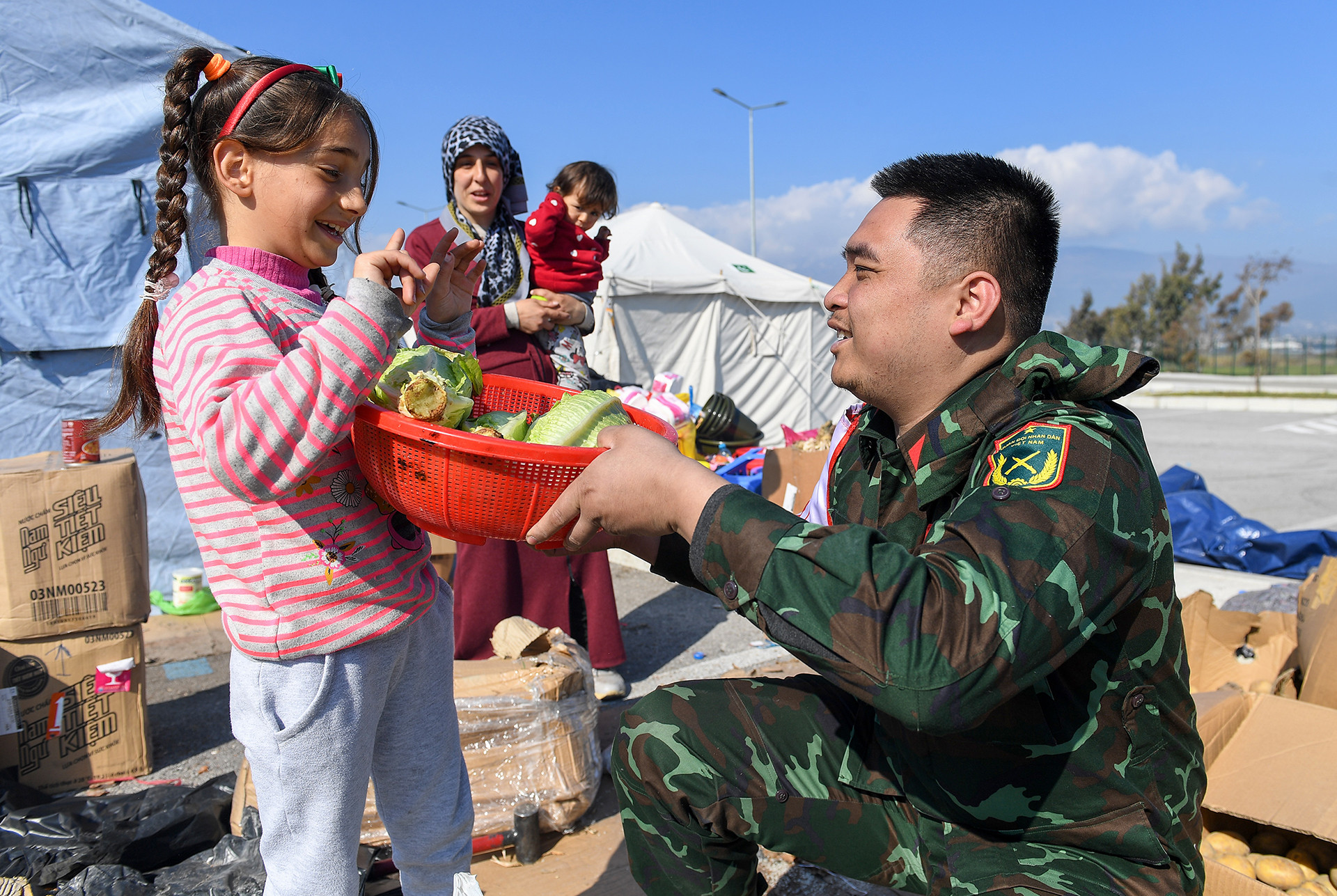 Cô bé người Syria tị nạn tại Hatay bất ngờ trước món quà nhỏ mà các chiến sĩ Quân đội nhân dân Việt Nam tặng. Những cây bắp cải còn tươi xanh sẽ giúp bữa ăn của cô bé thêm chất lượng.