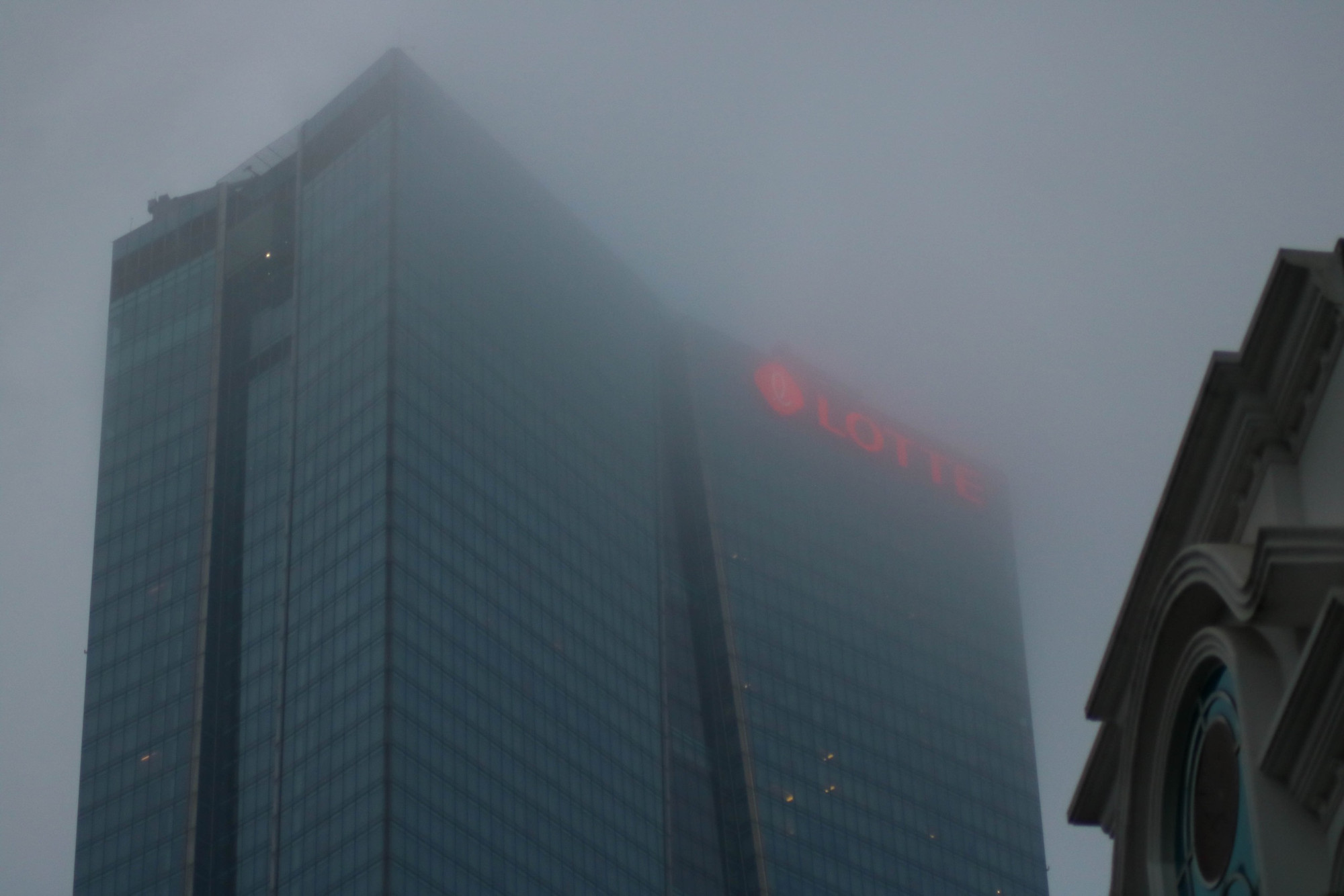 Nóc toà nhà Lotte (Liễu Giai, Hà Nội) mù mịt trong sương bụi.