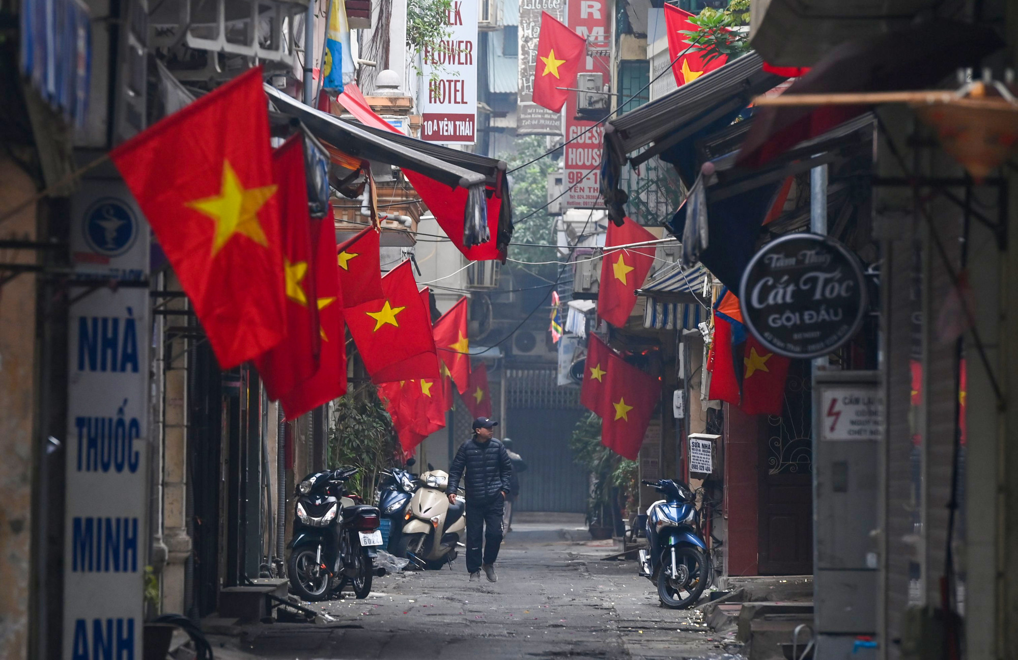 Những con phố nhỏ rực rỡ cờ hoa lác đác vài bóng người đi chúc Tết sớm trong sáng mùng Một Tết. (Ảnh: THÀNH ĐẠT)