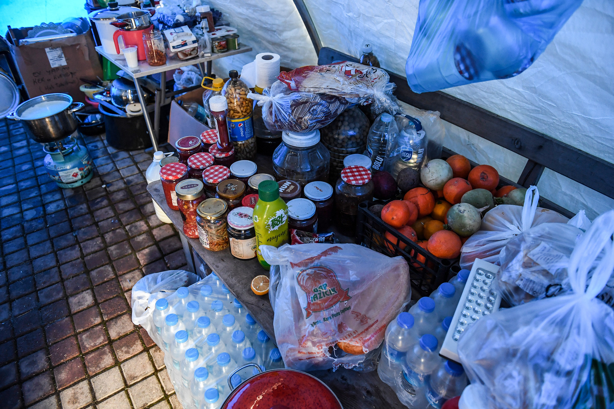 Bên trong khu bếp là những đồ ăn, thức uống được cứu trợ hoặc số ít đồ dùng còn sót lại dưới đống đổ nát.