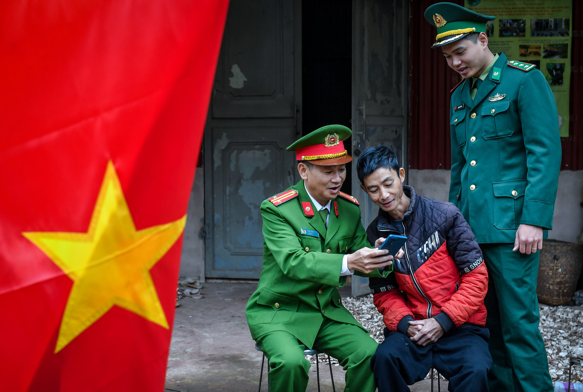 Trung tá Đặng Đình Hoan hướng dẫn người dân tại Sín Thầu cài phần mềm VNEID.