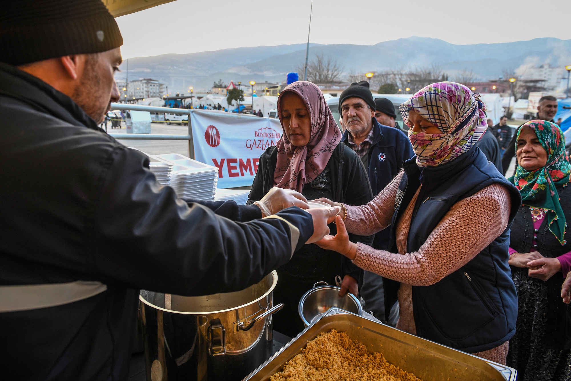 Cứ đến 5 giờ chiều, các tổ chức viện trợ phát cơm và đồ ăn miễn phí cho người dân thành phố "lều trại".