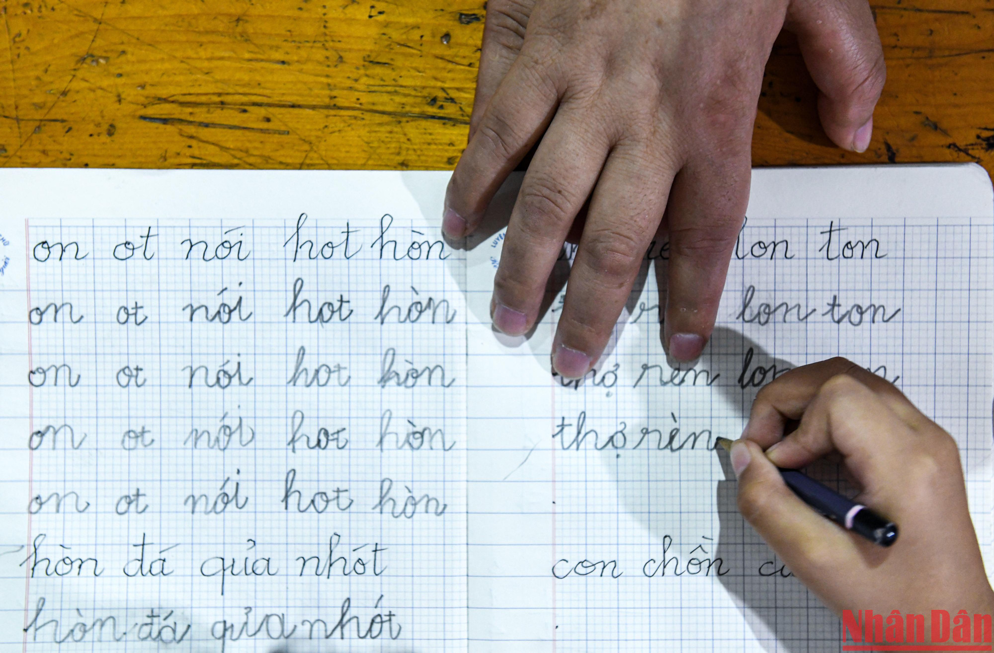 Những nét chữ đã dần đẹp hơn dưới bàn tay chỉ dạy của người thầy tật nguyền. (Ảnh: THÀNH ĐẠT)