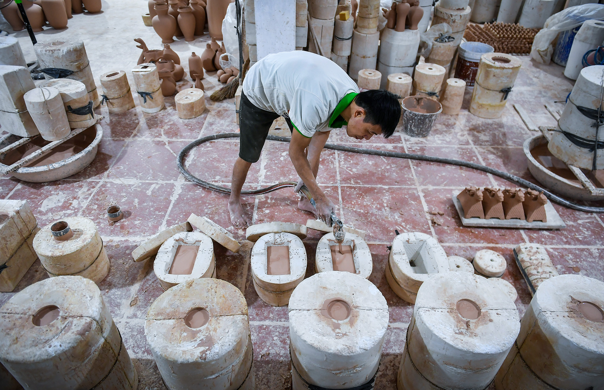 Quá trình tạo nên sản phẩm gốm tuân thủ các bước hết sức chặt chẽ. Đất sét sau khi được nhào nặn bằng máy sẽ được thợ bơm đầy các khuôn được làm từ trước.