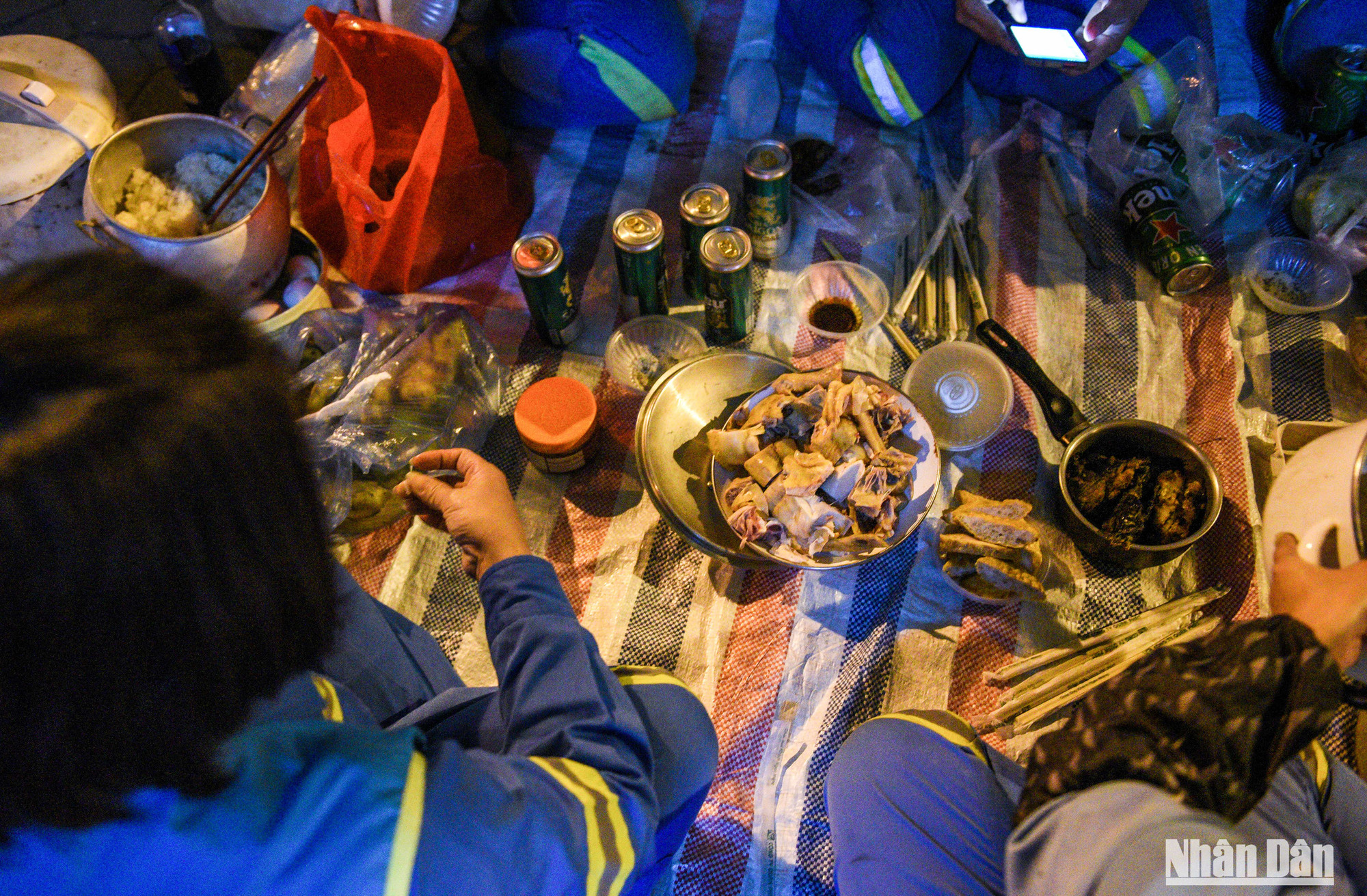 "Có xôi, có gà, chúng tôi lại cắm thêm nồi cơm, mang nồi cá trê kho sẵn ở nhà ra là đã có đủ đồ để làm bữa ăn Tất niên rồi", chị Quang, người công nhân có thâm niên 20 năm đón Tết ngoài đường cười nói.