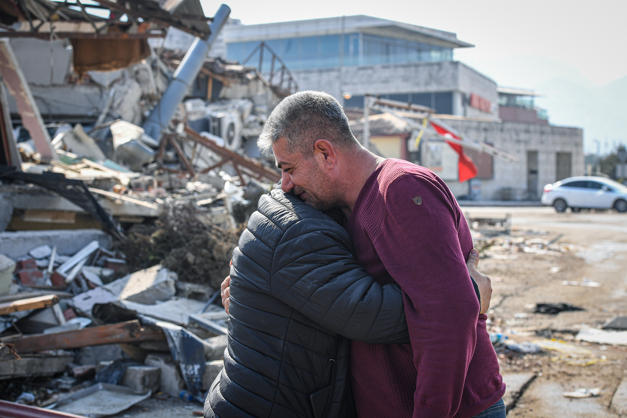 Hai người đàn ông quen biết ôm nhau sau khi biết bạn mình đã an toàn gần tòa nhà bị sập ở Hatay, Thổ Nhĩ Kỳ, ngày 23/2/2023.