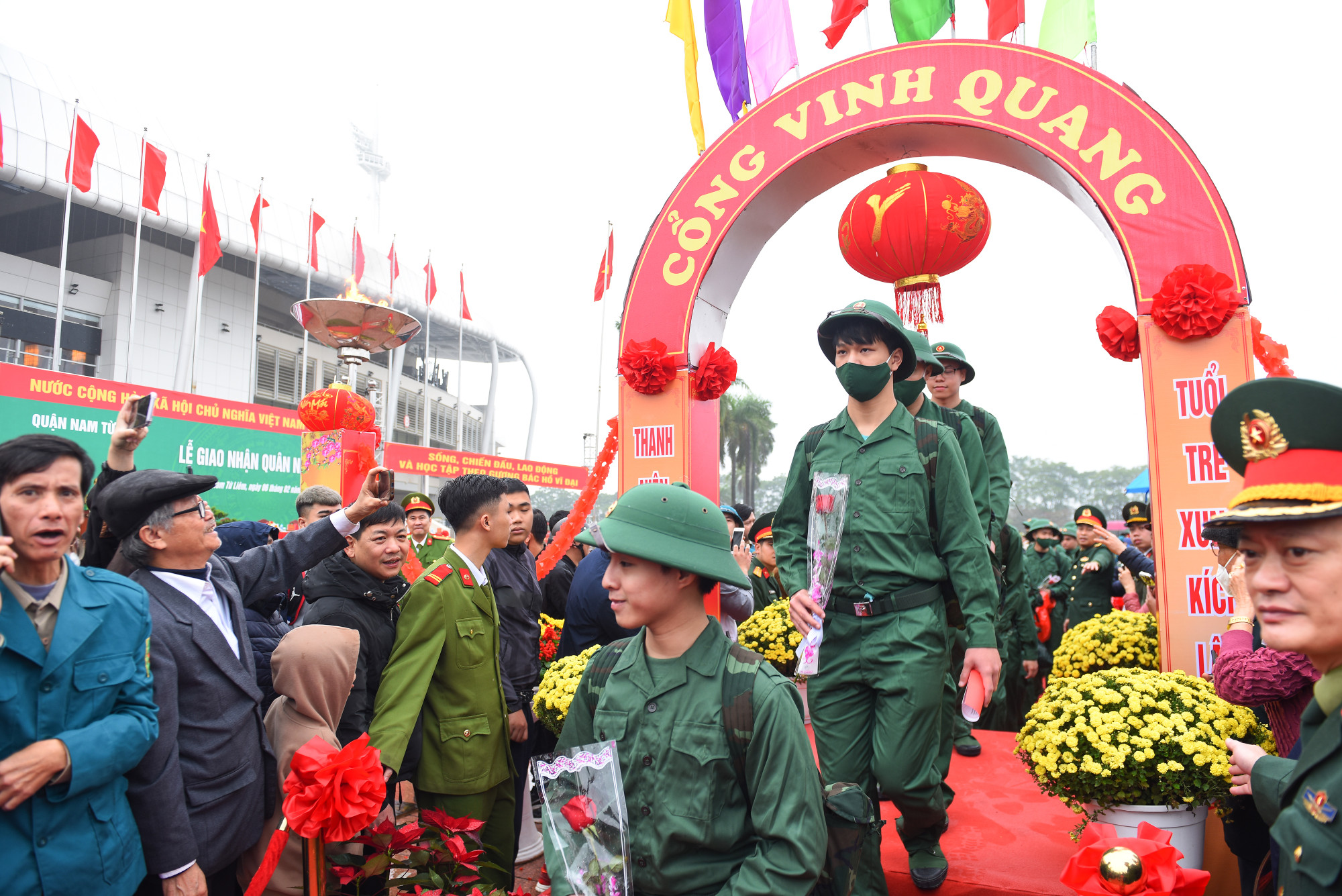 Giây phút các tân binh bước qua Cổng Vinh quang để chuẩn bị lên xe trở về đơn vị. Xung quanh, hàng chục người thân, bạn bè đã vây kín để đưa tiễn.