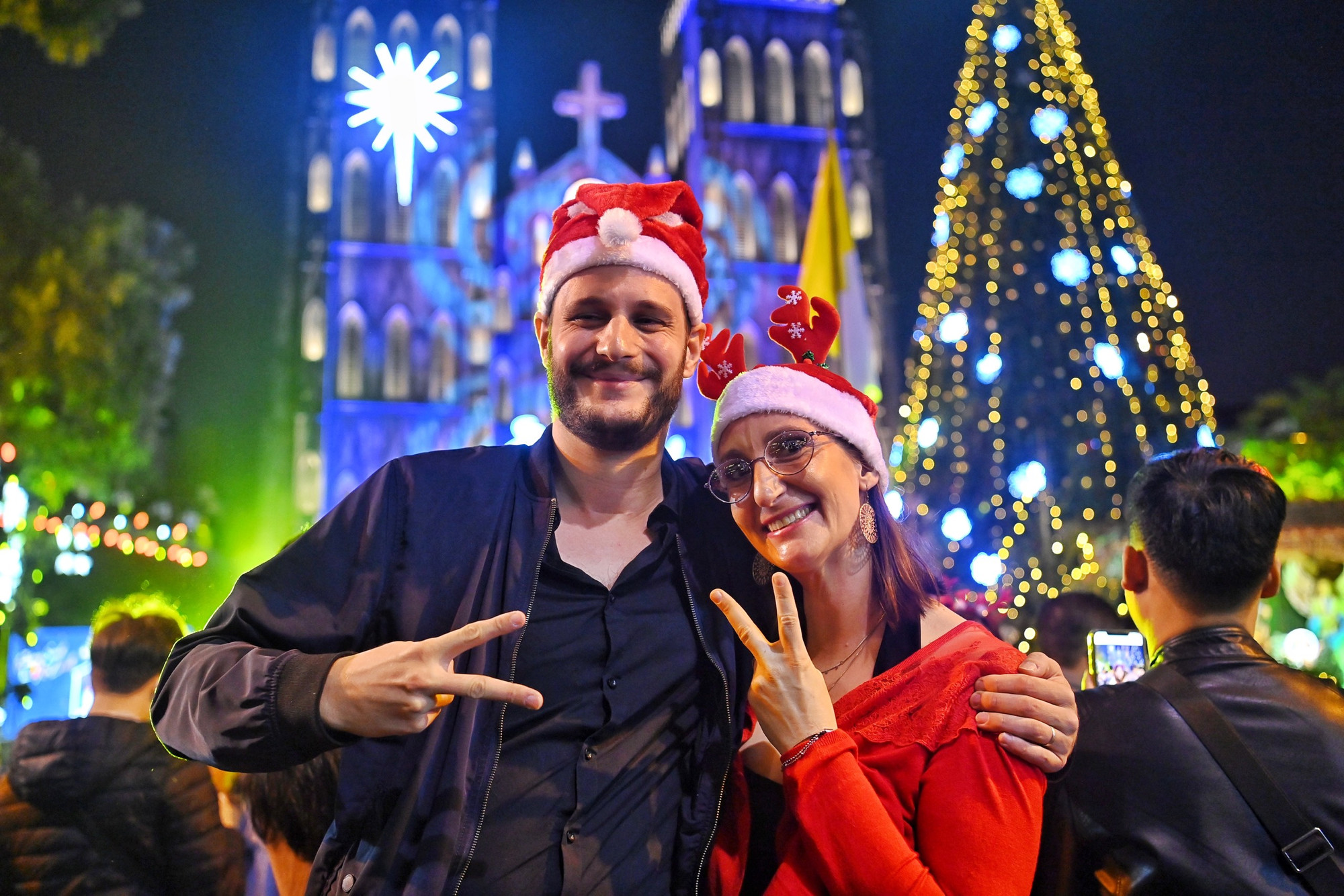 Một cặp đôi người nước ngoài tận hưởng không khí Giáng sinh tại Nhà thờ Lớn. (Ảnh: THÀNH ĐẠT)