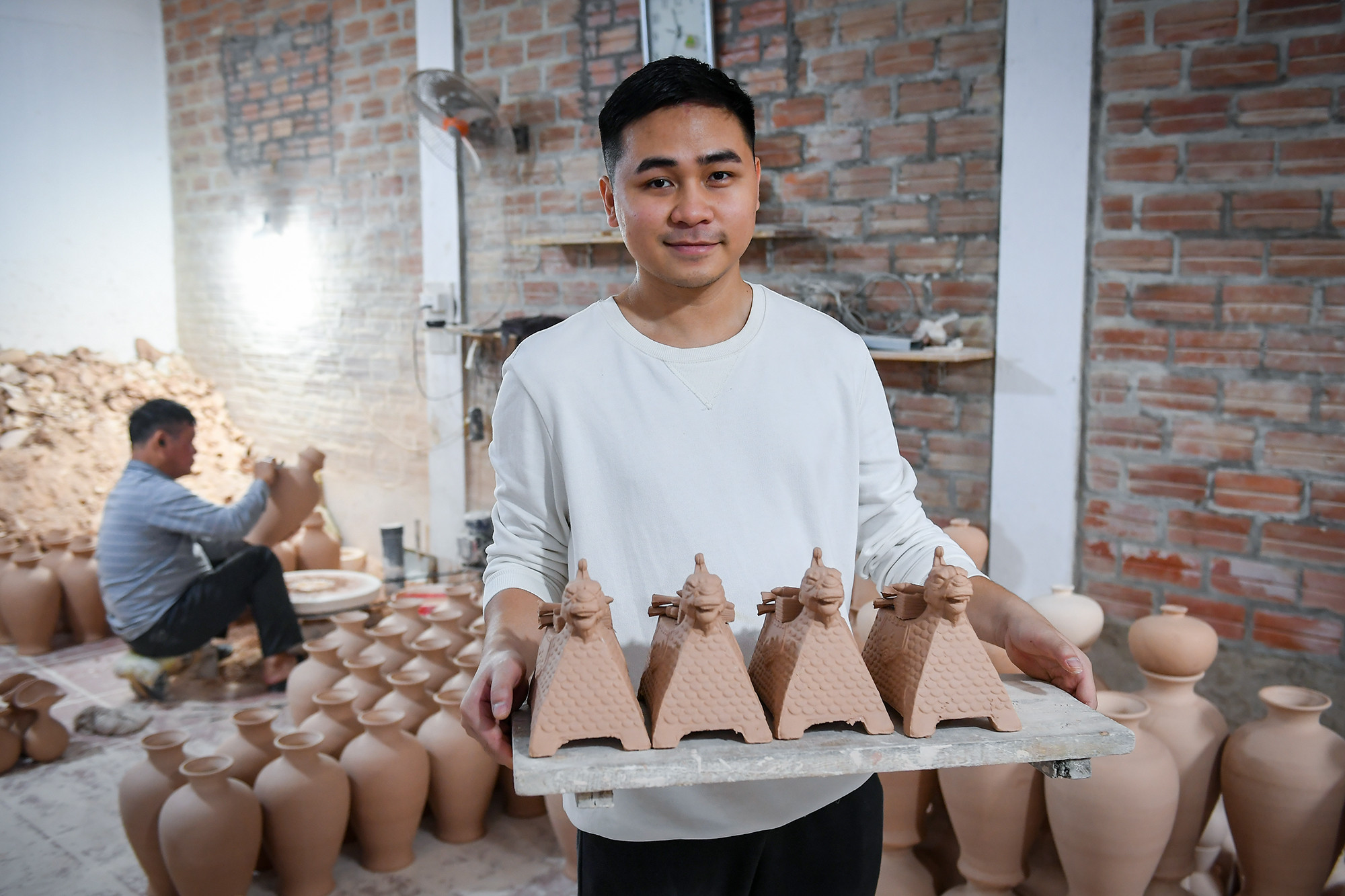 Nghệ nhân trẻ Trần Anh Tú với các sản phẩm của mình.