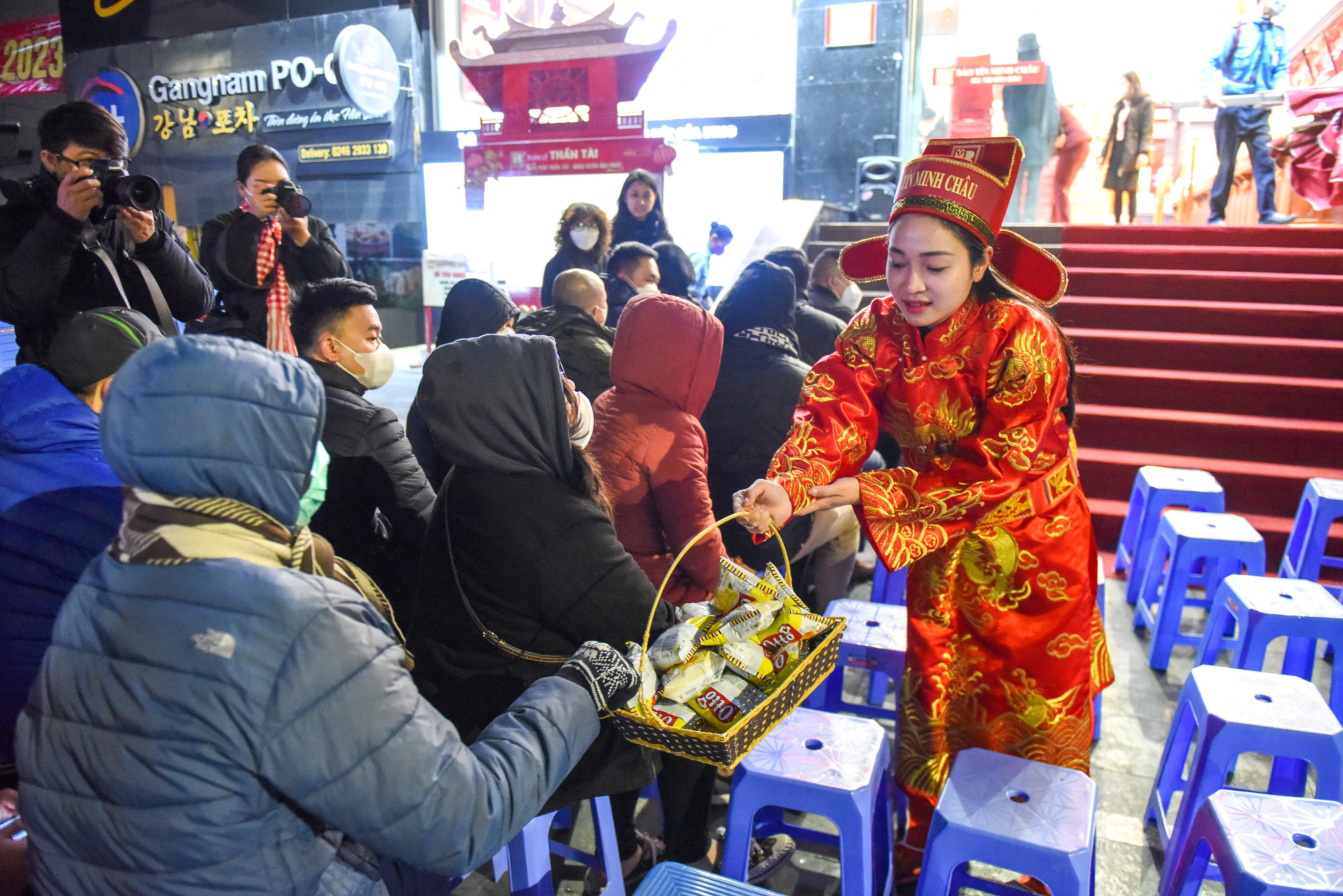 Nhân viên trong trang phục Thần Tài tặng bánh cho khách hàng trong thời gian chờ đợi.