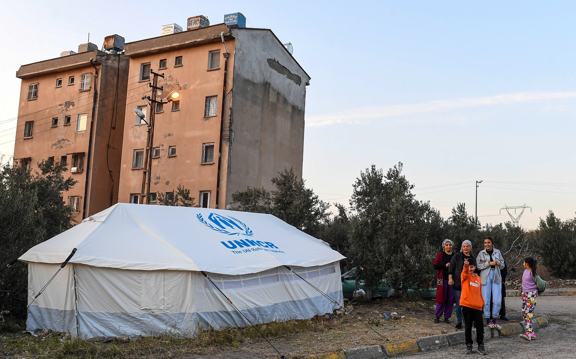 Mặc dù nằm khá xa tâm chấn, thế nhưng khu vực Sokak, Iskenderun (tỉnh Hatay) vẫn chịu ảnh hưởng của các trận động đất liên tiếp vừa qua. Những toà chung cư cũ màu vàng nâu phía sau với hơn 40 năm tuổi đã xuất hiện những vết nứt sau địa chấn. Điều này khiến tất cả các hộ dân sinh sống tại đây phải di chuyển ra bên ngoài ở để bảo đảm an toàn.