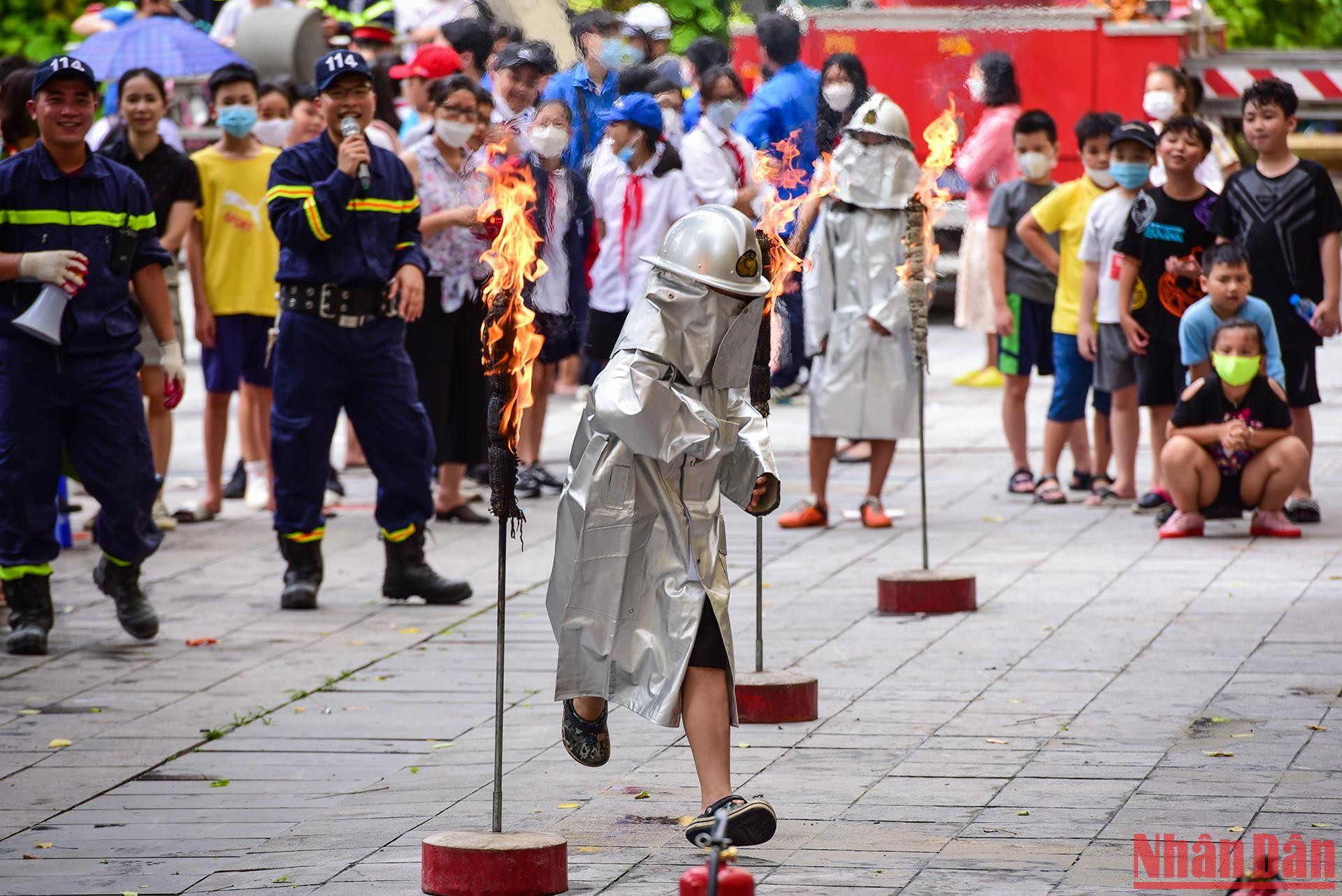 Các em học sinh trong trang phục chuyên dụng của Cảnh sát PCCC vượt chướng ngại vật lửa như những người lính thực thụ.