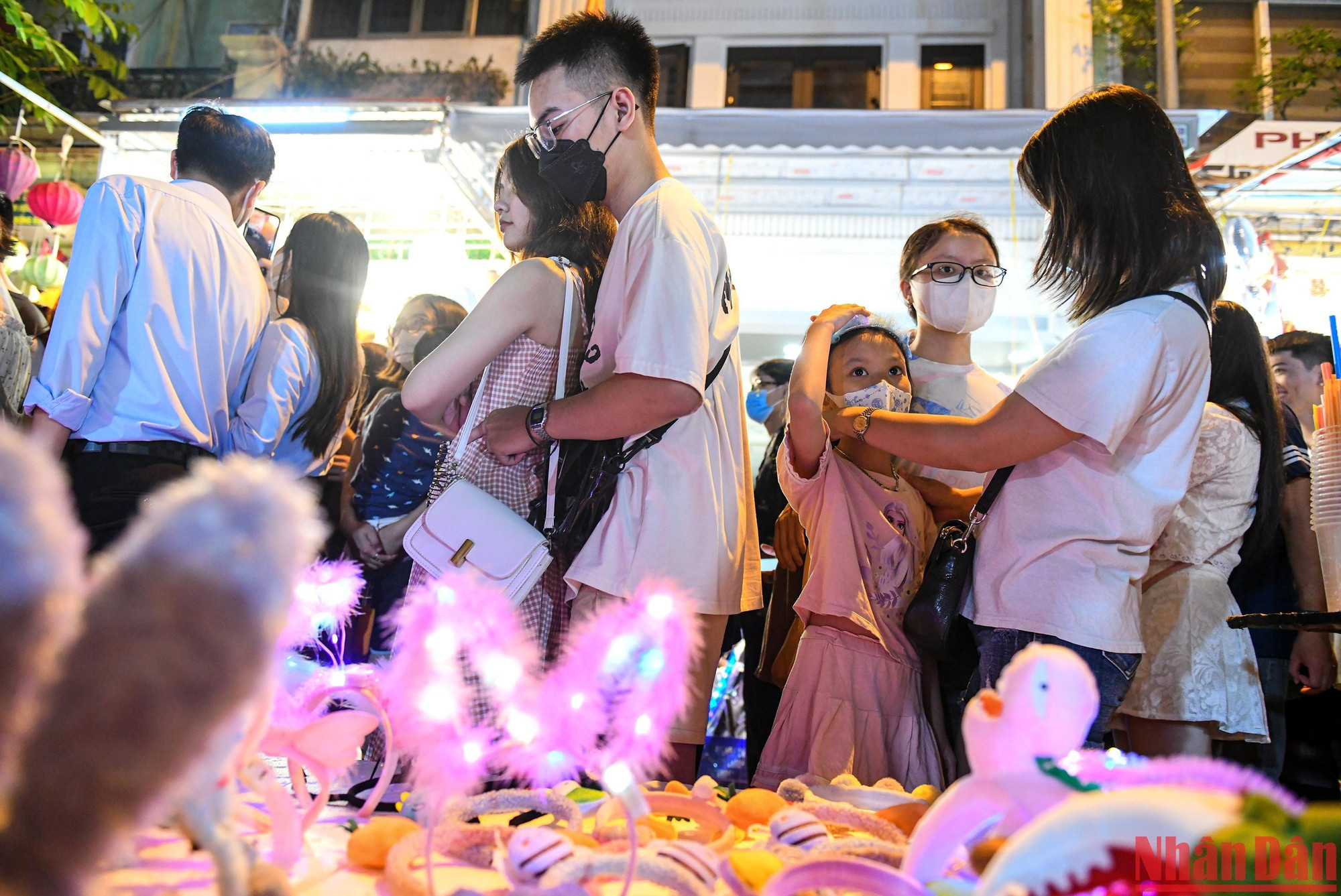 Các em bé lớn hơn có thể may mắn chọn cho mình chỗ đứng chật hẹp để mua đồ chơi Trung thu cùng bố mẹ.