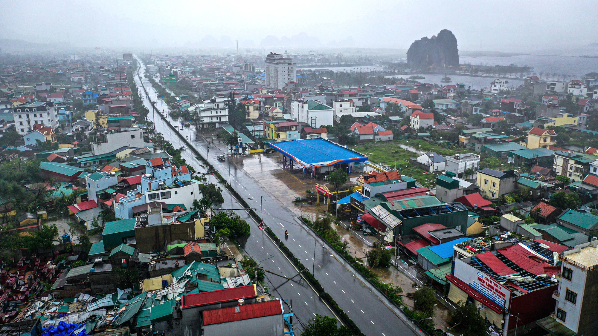 Ở góc nhìn này, có thể thấy cả hai bên trục Quốc lộ 18 đoạn qua phường Cẩm Sơn, thành phố Cẩm Phả đều la liệt những ngôi nhà bị bay mái.
