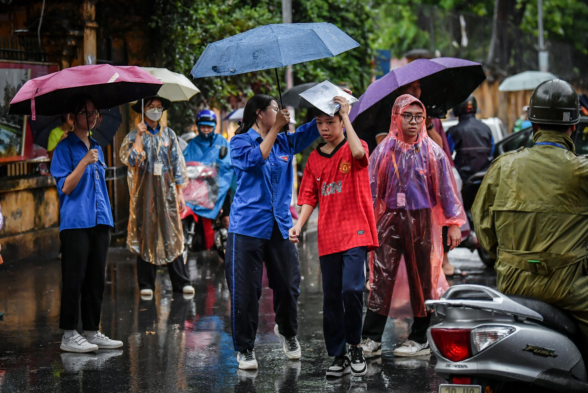 Các thí sinh được lực lượng sinh viên tình nguyện hỗ trợ hết mình dưới cơn mưa tầm tã đầu giờ sáng.