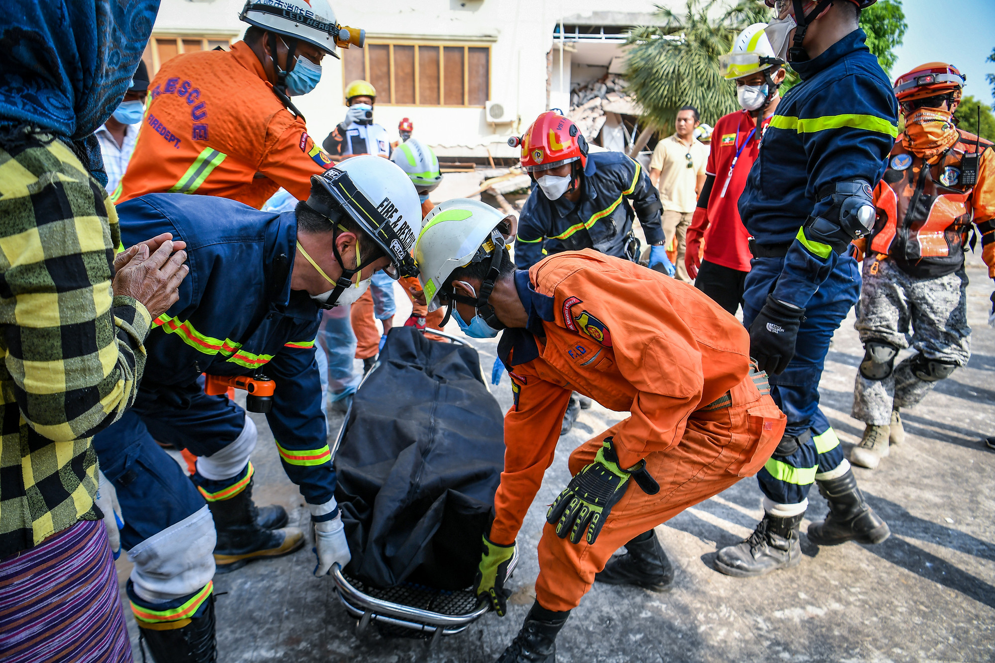 Lực lượng cứu nạn, cứu hộ Bộ Công an Việt Nam đưa thi thể nạn nhân ra khỏi một ngôi nhà bị sập tại Naypyidaw, Myanmar.