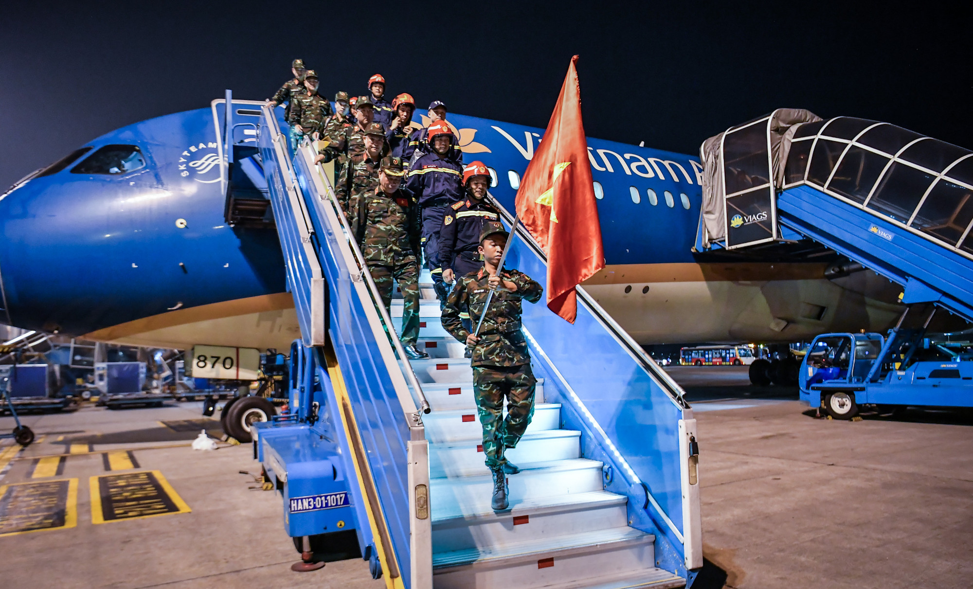 Đúng 20 giờ ngày 8/4, lá Quốc kỳ dẫn đầu theo sau là đoàn công tác đã xuống máy bay.