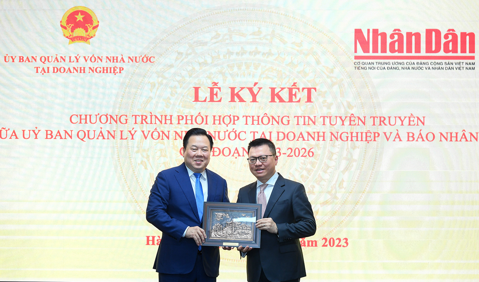 Chủ tịch Ủy ban Quản lý vốn nhà nước tại doanh nghiệp Nguyễn Hoàng Anh trao quà lưu niệm cho Báo Nhân Dân.