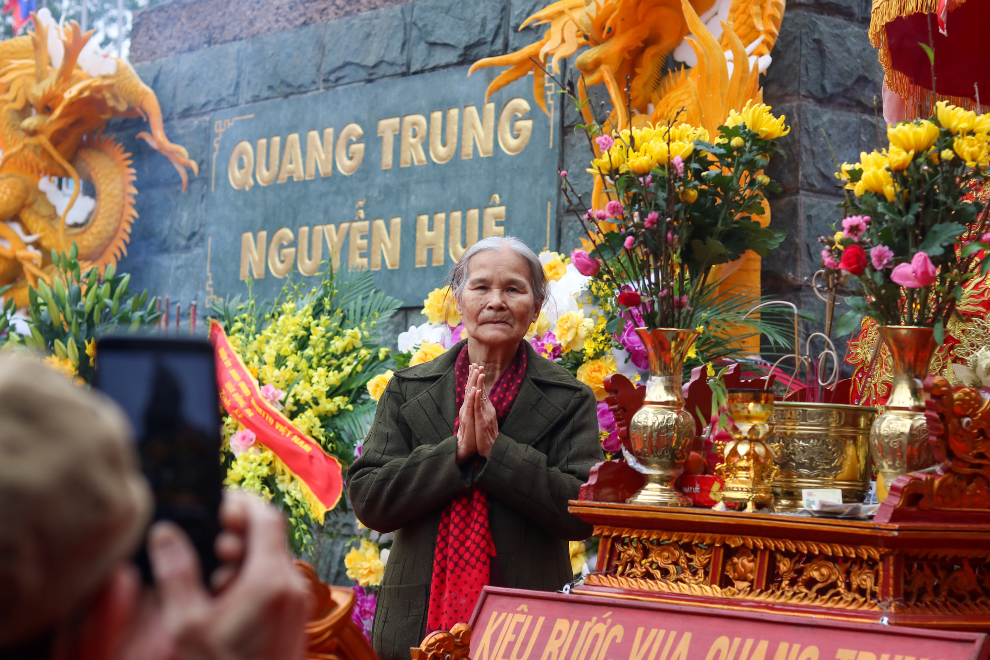 Một cụ bà cao tuổi kính cẩn chắp tay tưởng nhớ đến vị vua vĩ đại của dân tộc Việt Nam. (Ảnh: NHẬT QUANG)