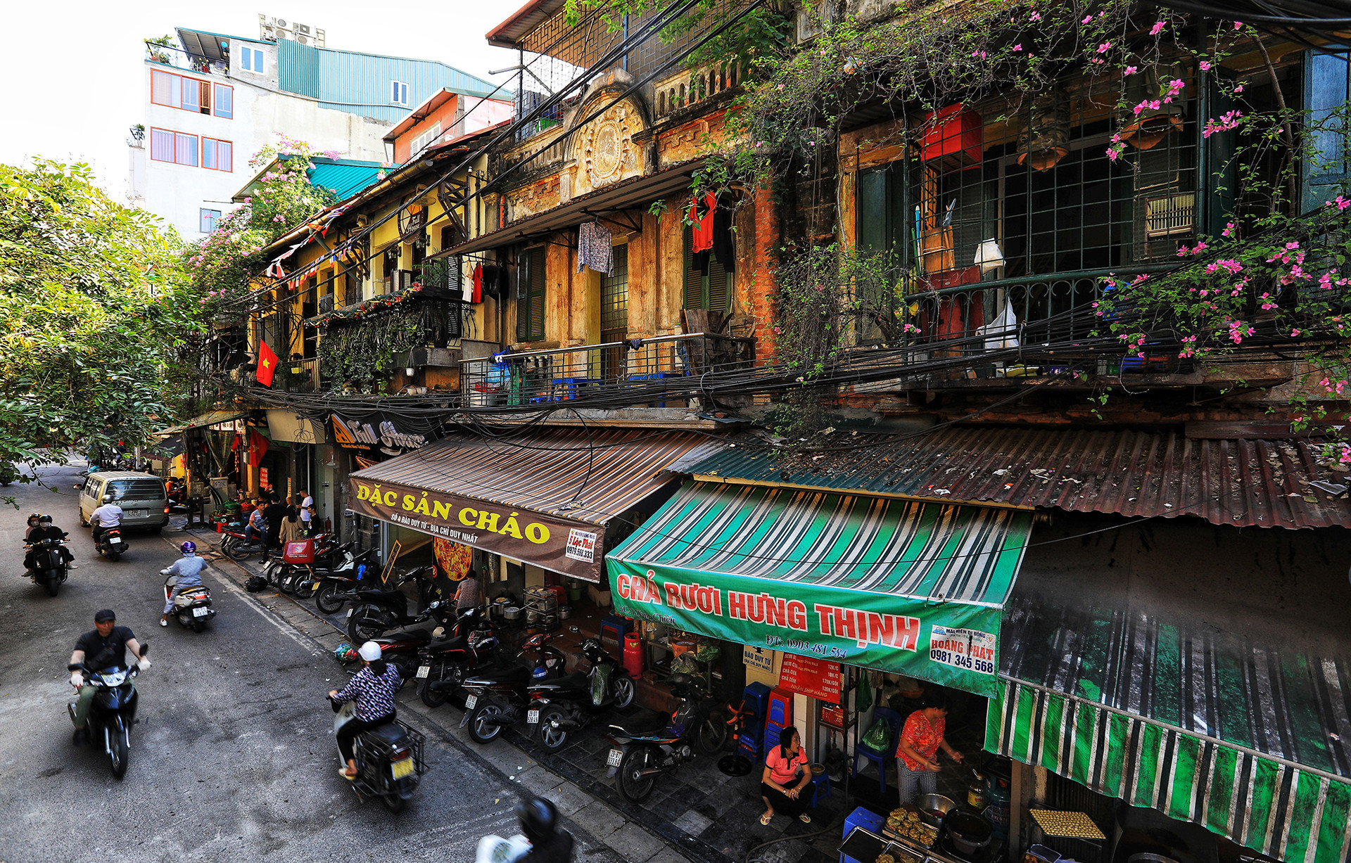 Một góc phố Đào Duy Từ được chụp từ độ cao hơn 10m, có thể thấy rõ hơn những khu nhà cổ kính tường vàng rêu phong ở tầng hai, dưới tầng một là nơi buôn bán ẩm thực của người dân.