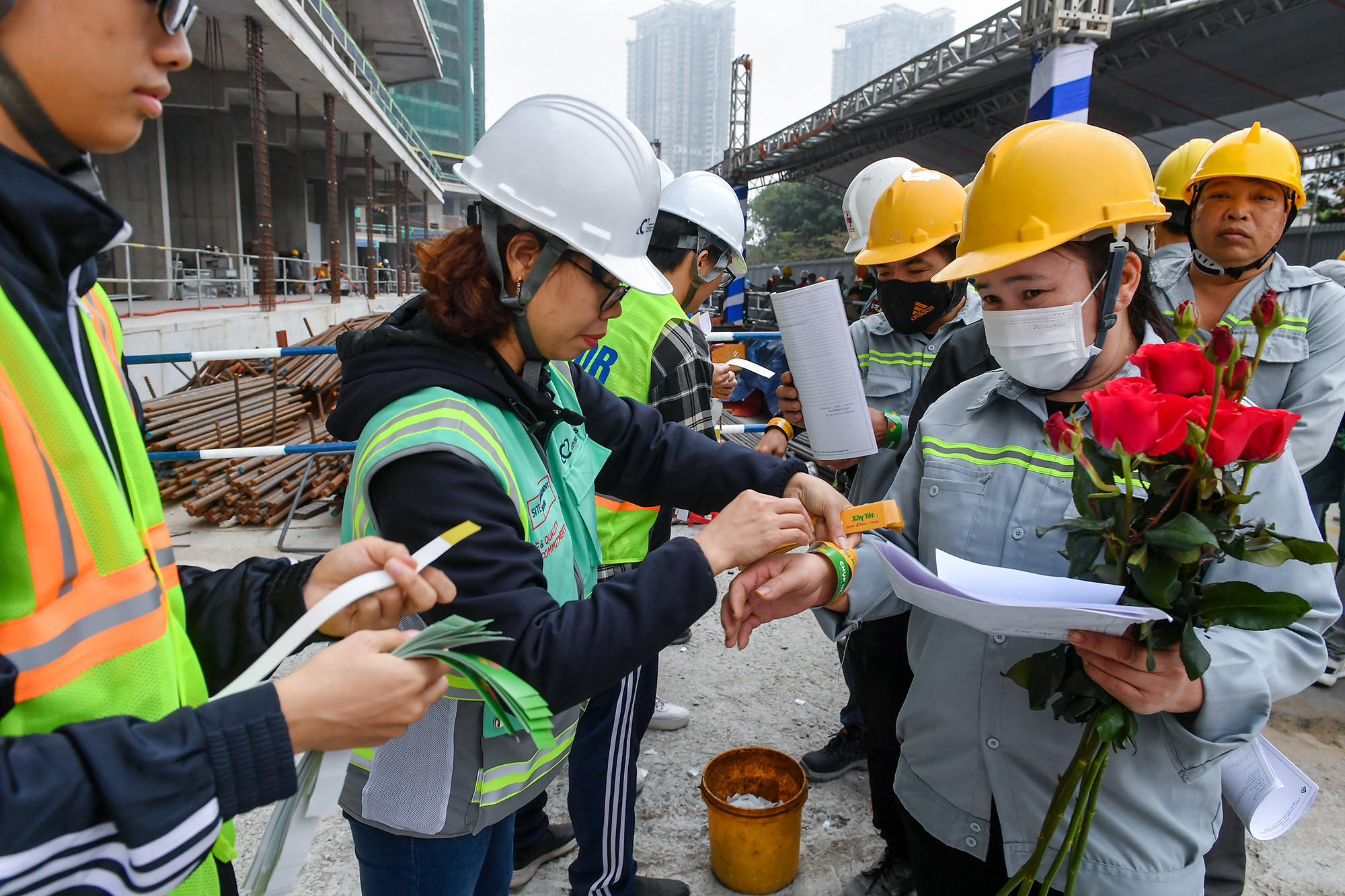 Các công nhân được gắn vòng để chuẩn bị nhận quà cũng như làm thủ tục khám bệnh ngay tại công trường.