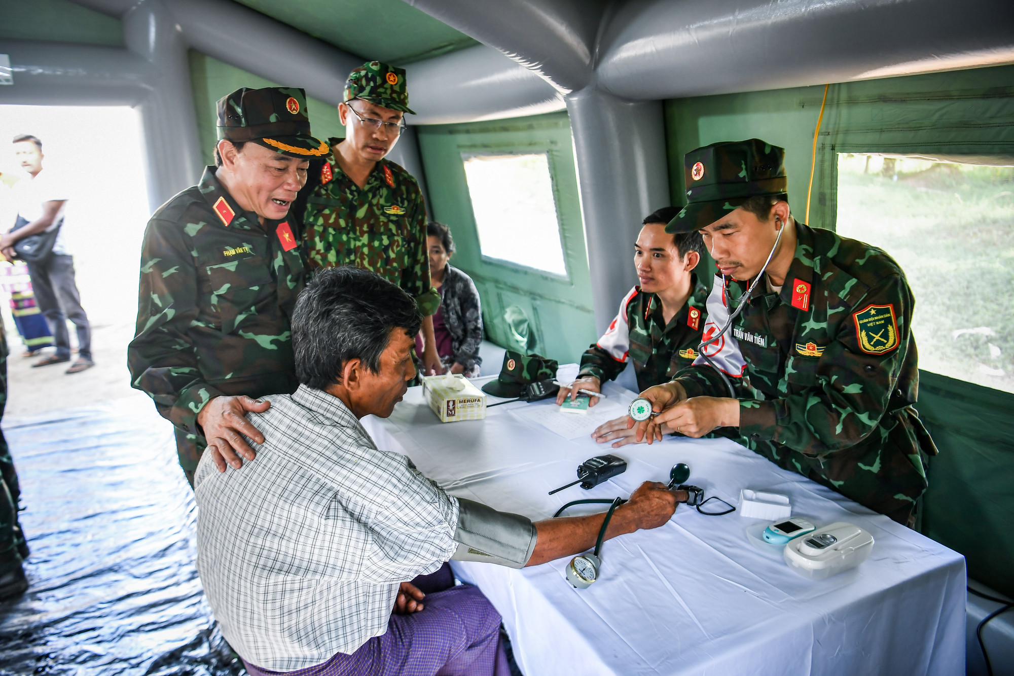 Thiếu tướng Phạm Văn Tỵ, Trưởng đoàn công tác cùng anh em Quân y thăm hỏi động viên những người nhà của các nạn nhân vẫn đang nằm dưới đống đổ nát giữ gìn sức khoẻ.