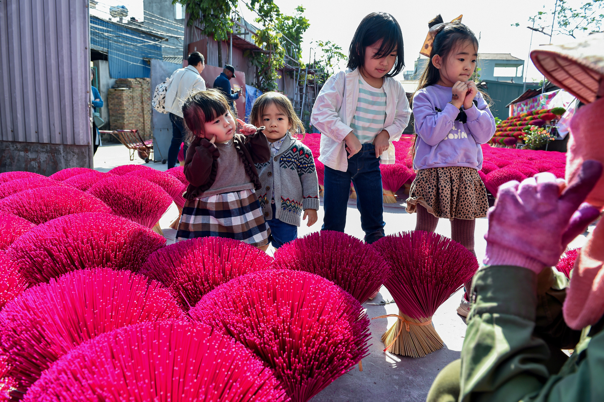Các em nhỏ ngoại quốc khá thích thú và tò mò trước những bó hương sặc sỡ sắc màu của Việt Nam.
