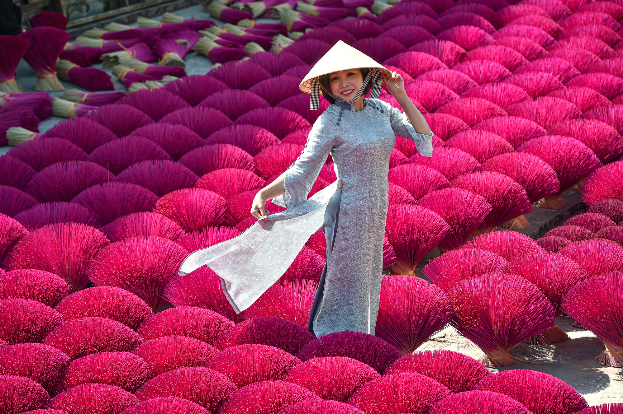 Chiếc áo dài truyền thống VIệt Nam đẹp mê hồn bên khung cảnh rực rỡ của những bó hương đỏ.