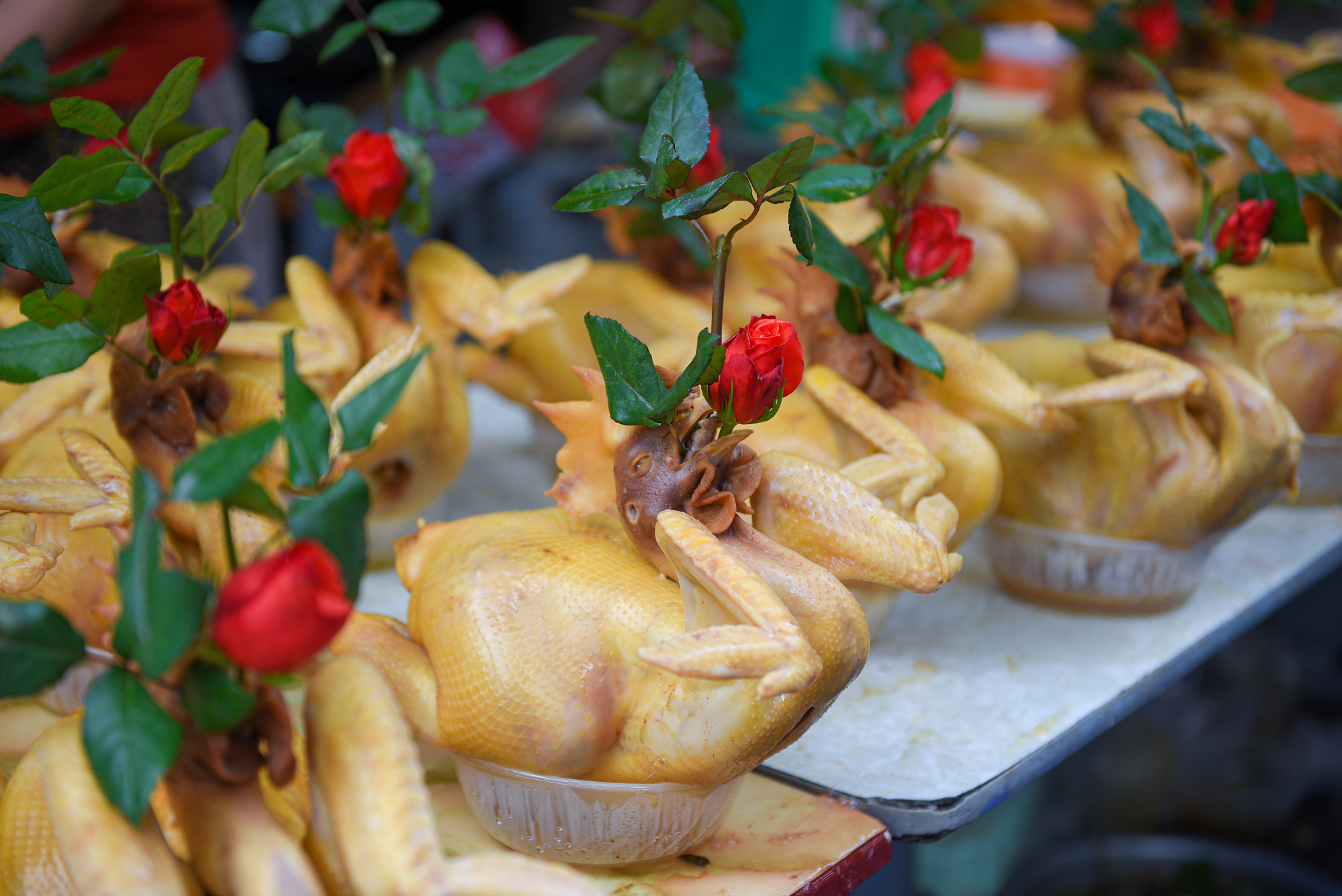 Gà luộc sẵn ở đây không chỉ ngon có tiếng mà gà ngậm hoa hồng được trang trí để phù hợp với mâm cúng lễ.