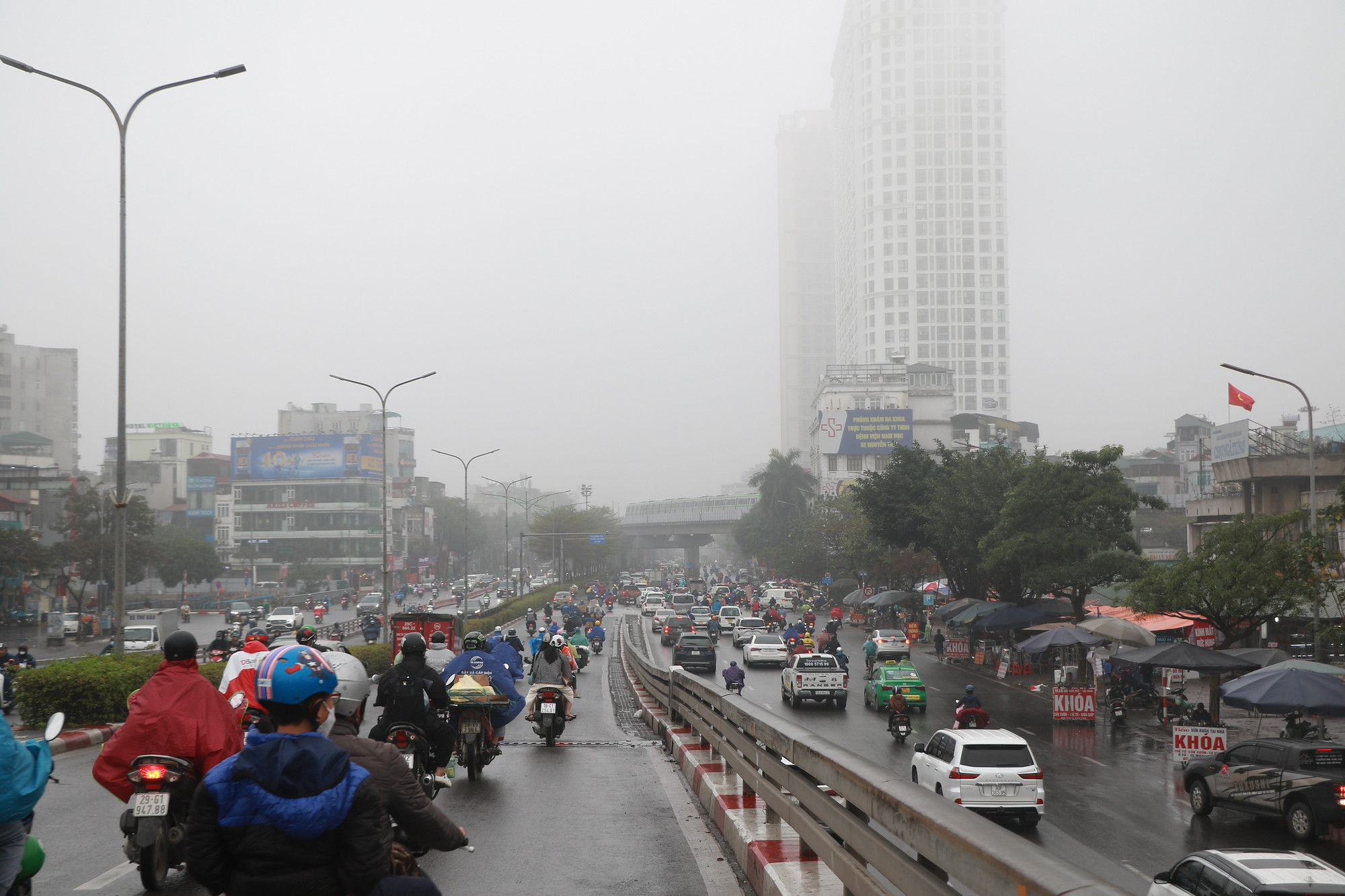 Mưa phùn vào đúng giờ đi làm của người dân khiến việc di chuyển trở nên khó khăn.