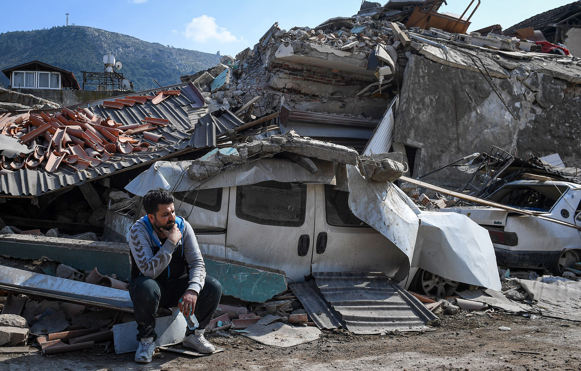 Tại khu chợ cổ Kurtulus (Antakya), người đàn ông trầm ngâm nghĩ về tương lai. Phía sau, những dấu tích của thảm hoạ vẫn hiện rõ.