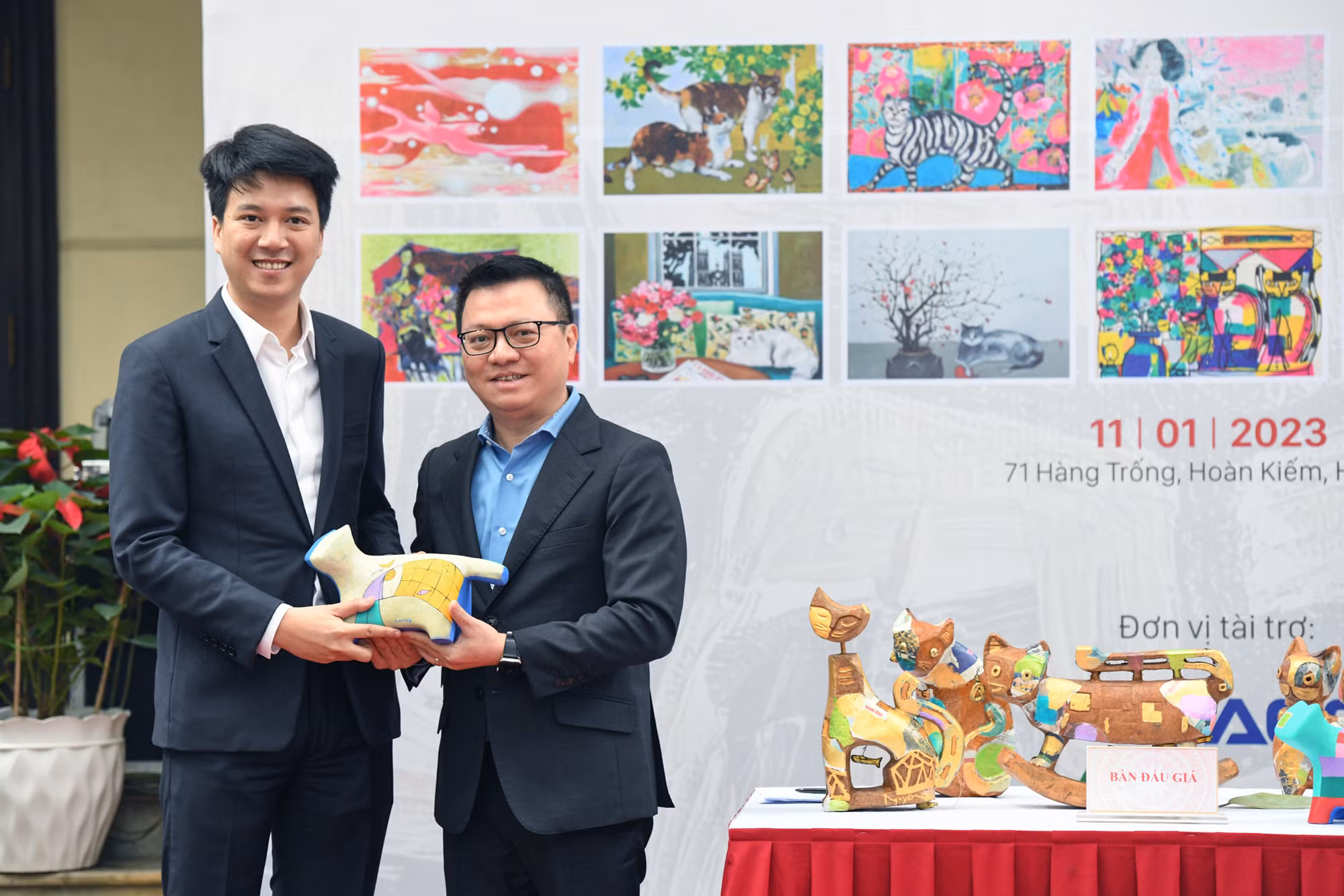Tổng Biên tập Báo Nhân Dân Lê Quốc Minh chụp ảnh cùng 1 vị khách đã đấu giá thành công linh vật Mèo độc bản. (Ảnh: THÀNH ĐẠT)