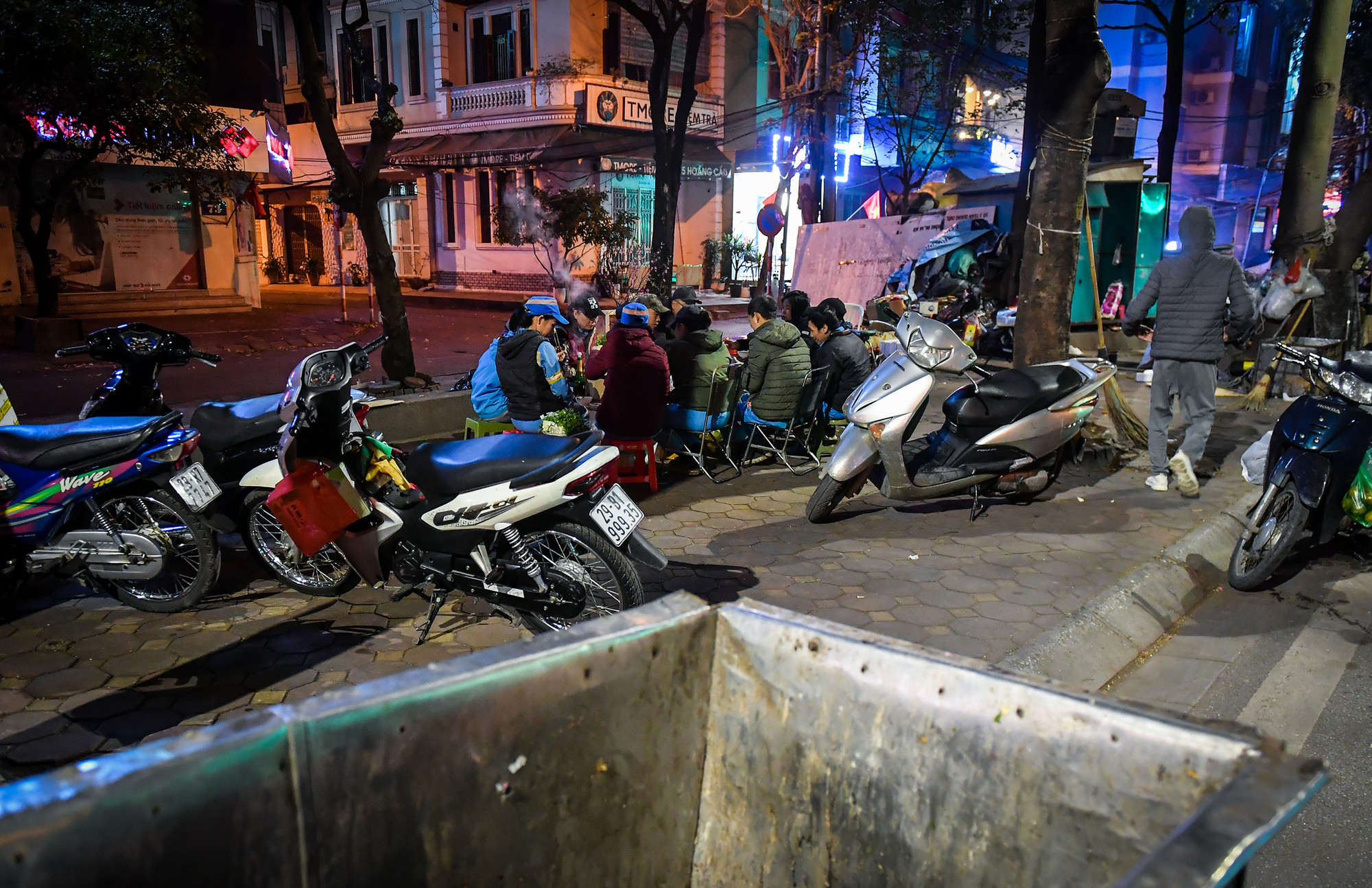 "Bàn ăn" được dựng từ vài chiếc hộp xốp đã cũ, phía trên phủ bạt. Ghế ngồi thì mỗi người mang theo một chiếc. Chỉ chừng 10 phút, mâm cơm tất niên của những công nhân môi trường tối 29 Tết đã sẵn sàng.