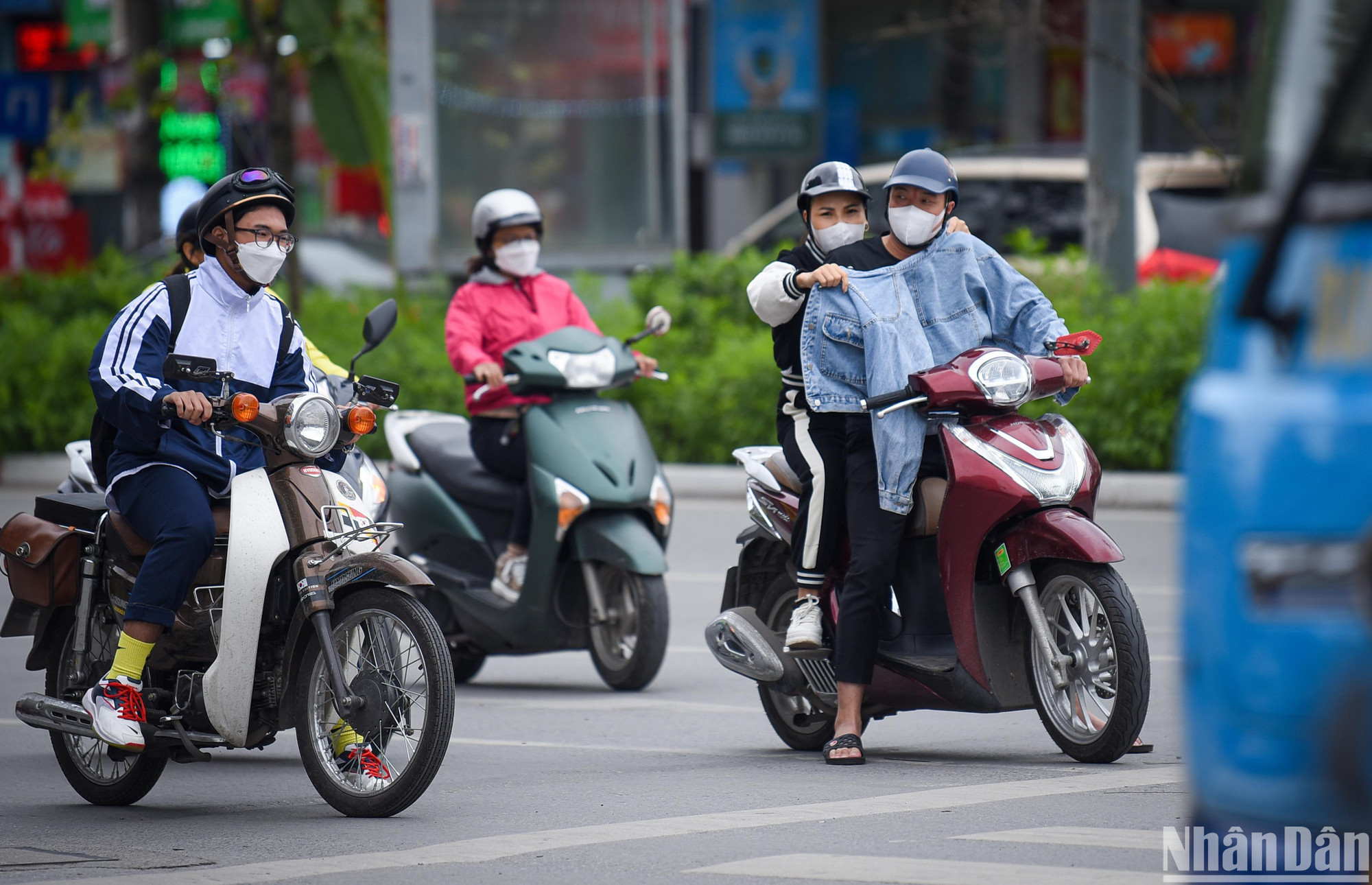 Người đi đường dùng mọi cách để tránh rét. (Ảnh: THÀNH ĐẠT)