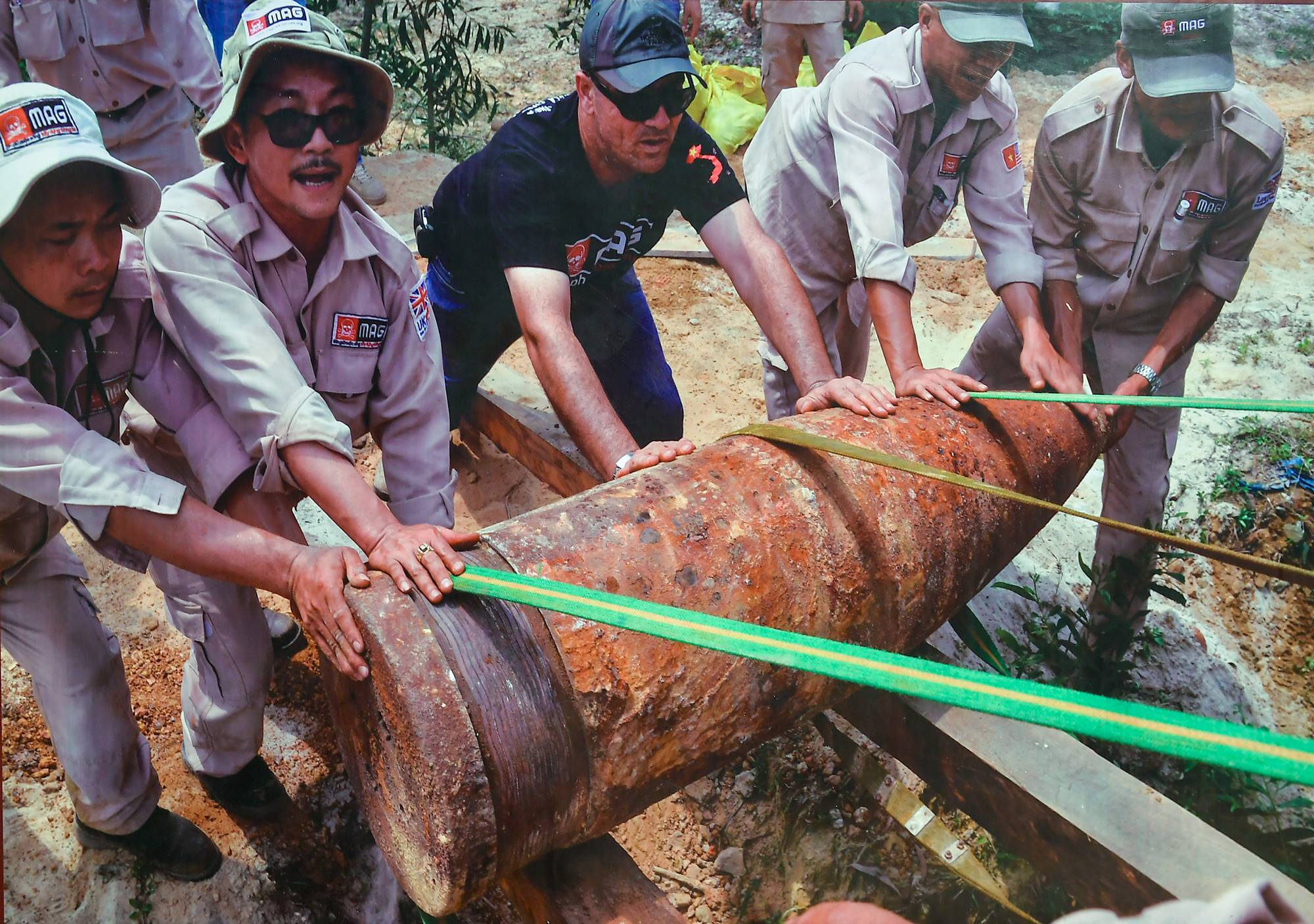 Kỹ thuật viên MAG nỗ lực di chuyển một trong hai quả đạn pháo nặng gần 900kg được phát hiện tại thôn Thuỷ Khê, huyện Gio Linh lên xe tải đến bãi huỷ nổ tập trung (Ảnh chụp tháng 4 năm 2016).