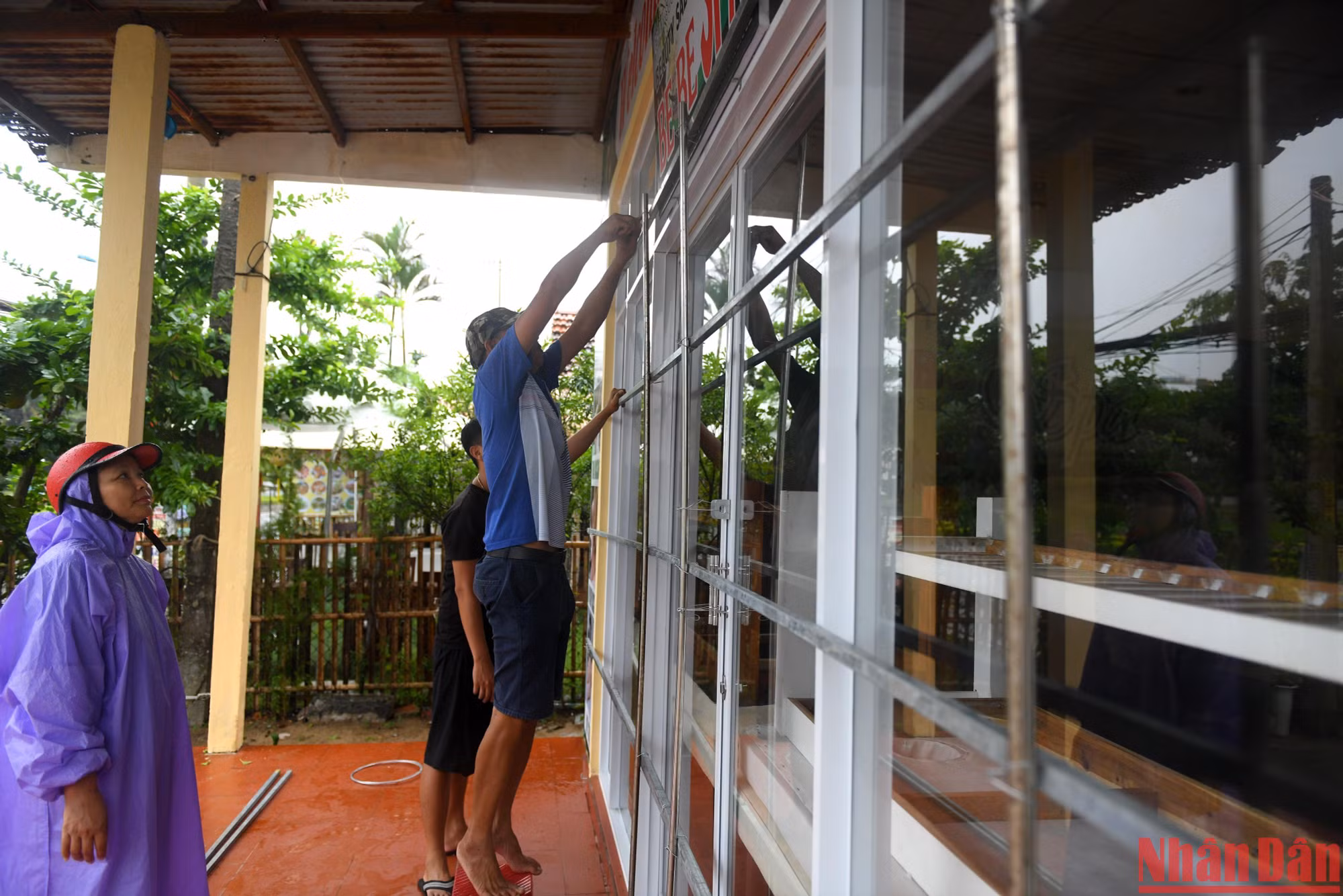 Các gia đình sinh sống ven biển Cửa Đại gia cố cửa trước giờ bão vào.