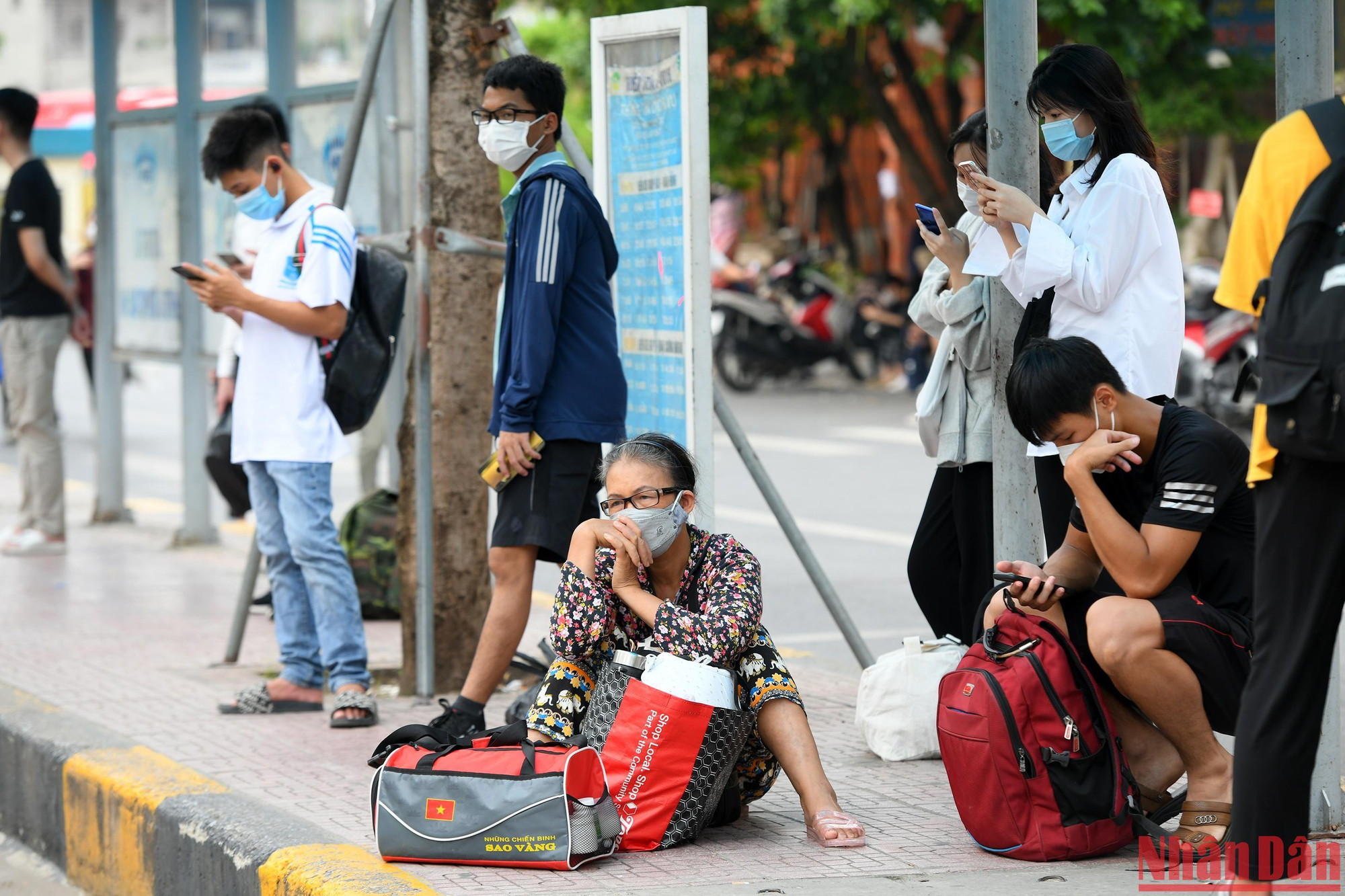 Một số người dân khệ nệ đồ đạc chờ đến giờ lên xe.