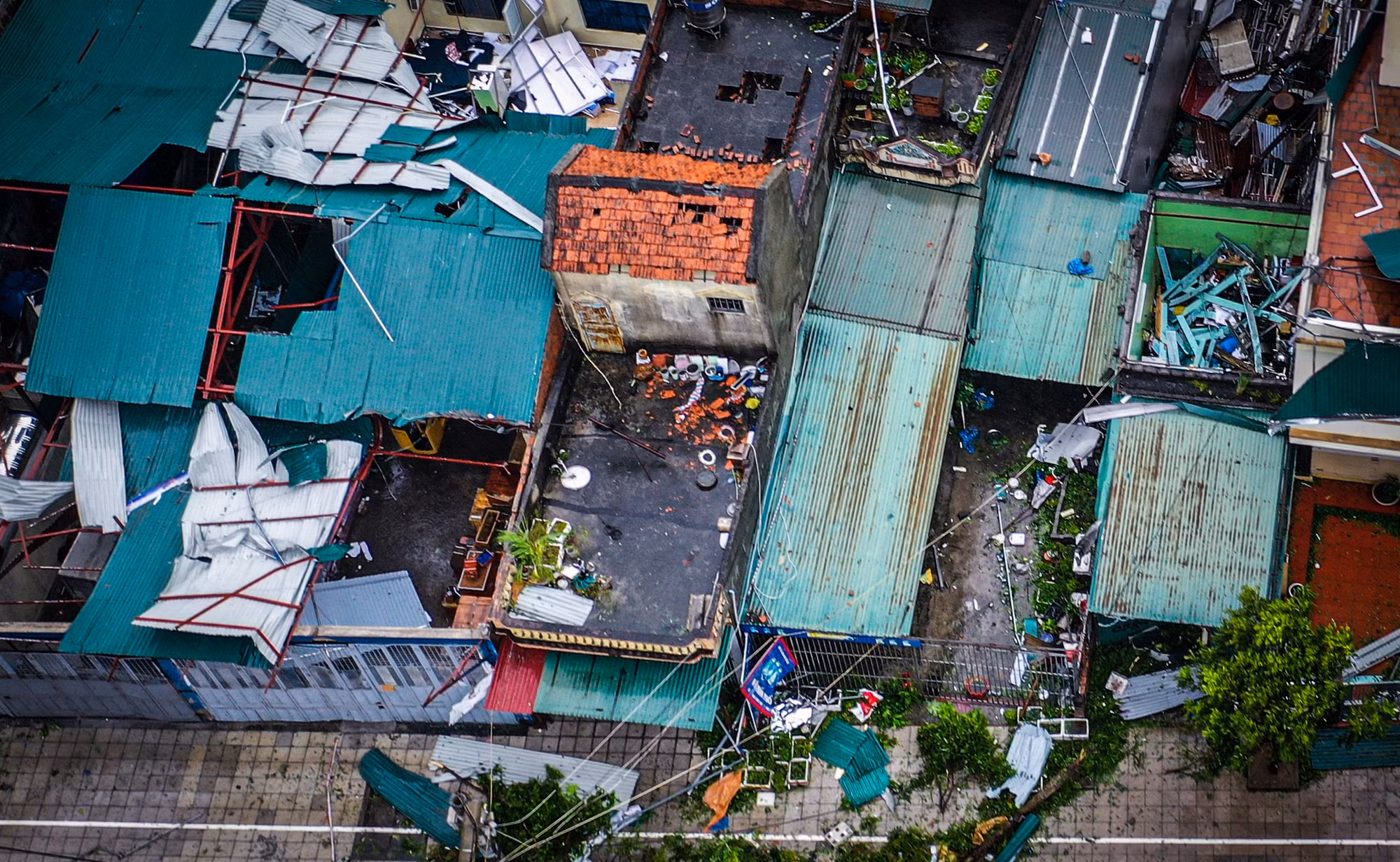 Không chỉ phần mái tôn màu xanh bị bão số 3 "bóc đi", ngay cả nóc nhà lợp ngói (ở giữa ảnh) cũng bị hư hại nghiêm trọng. Người dân Cẩm Phả hôm nay, 7/9, vô cùng lo sợ khi gió bão cuốn theo cả gạch vào không trung. Không chỉ phần mái tôn màu xanh bị bão số 3 "bóc đi", ngay cả nóc nhà lợp ngói (ở giữa ảnh) cũng bị hư hại nghiêm trọng. Người dân Cẩm Phả hôm nay, 7/9, vô cùng lo sợ khi gió bão cuốn theo cả gạch vào không trung.