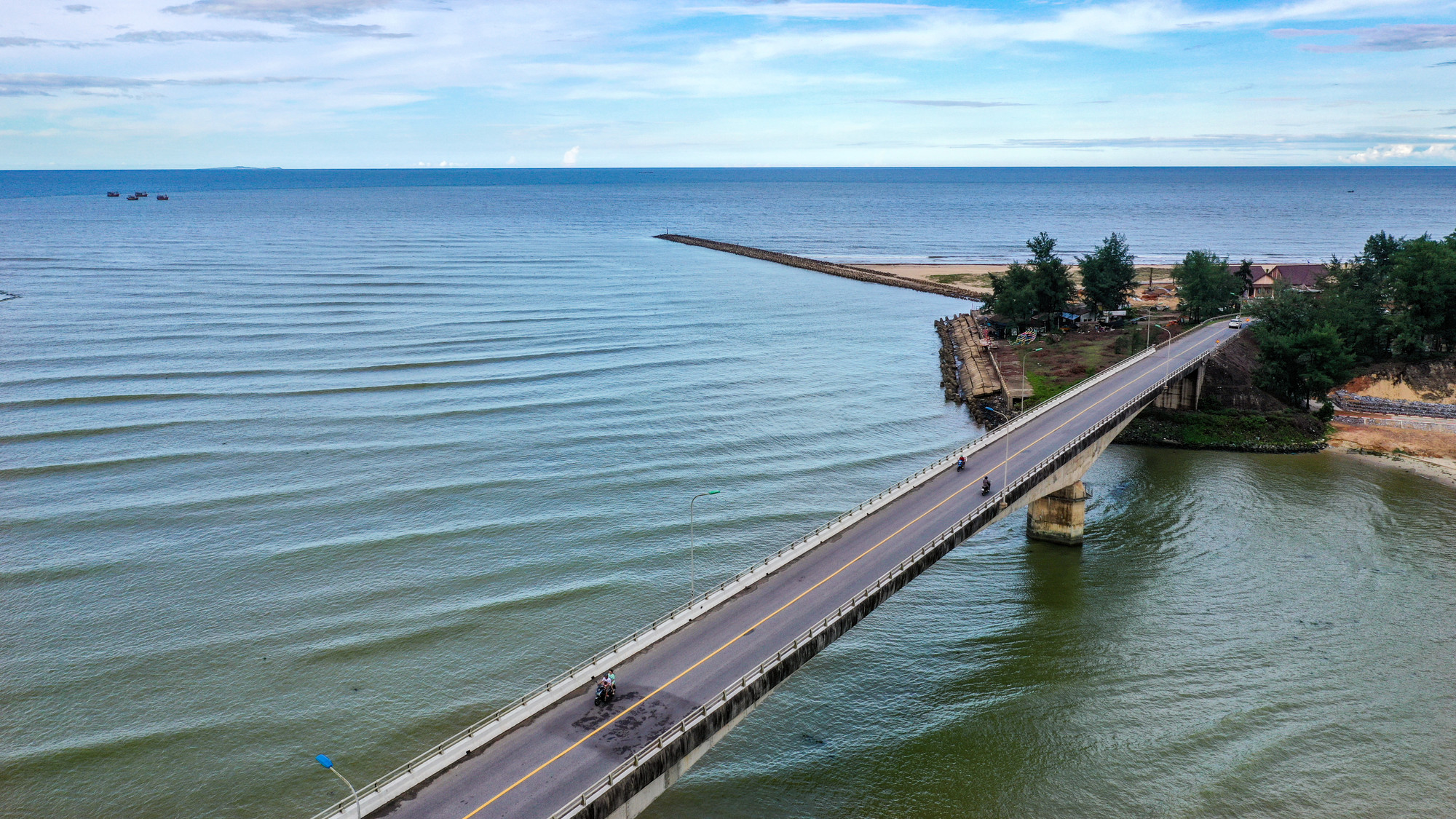 Biển Cửa Tùng nằm ngay điểm sông Bến Hải lịch sử dẫn ra cửa bể lớn... Đây cũng là "điểm nối" của một loạt các di tích lịch sử gắn với Vĩ tuyến 17 xưa kia. Bãi tắm Cửa Tùng cách không quá xa địa đạo Vịnh Mốc lẫn cầu Hiền Lương... Trong ảnh là cầu Cửa Tùng bắt qua cửa biển, nối hai huyện Vĩnh Linh và Gio Linh.