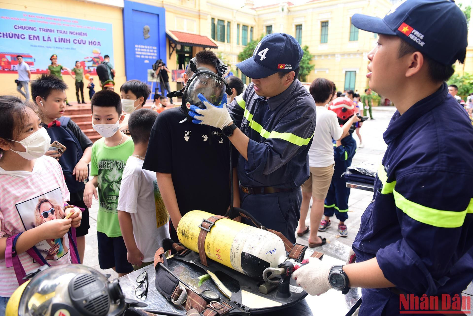 Các em nhỏ được trải nghiệm mặt nạ phòng độc của lực lượng cứu hộ.